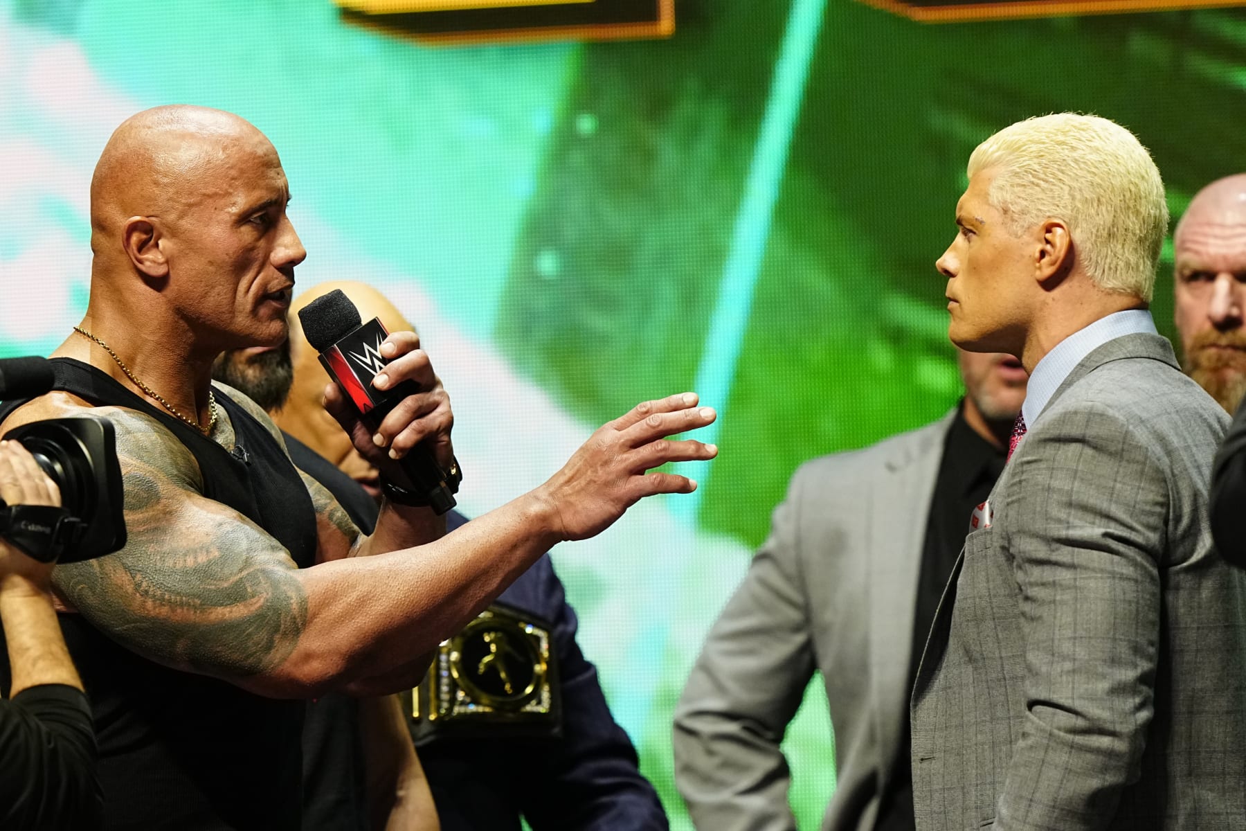 LAS VEGAS, NV - FEBRUARY 08:  Dwayne "The Rock" Johnson and Cody Rhodes face-off on stage during the WWE Wrestlemania XL Kickoff on February 08, 2024, at T-Mobile Arena in Las Vegas, NV. (Photo by Louis Grasse/PXimages/Icon Sportswire via Getty Images)