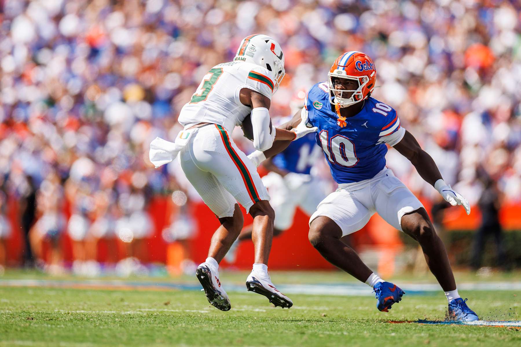 Jacolby George #3 of the Miami Hurricanes runs the ball against Grayson Howard #10 of the Florida Gators 