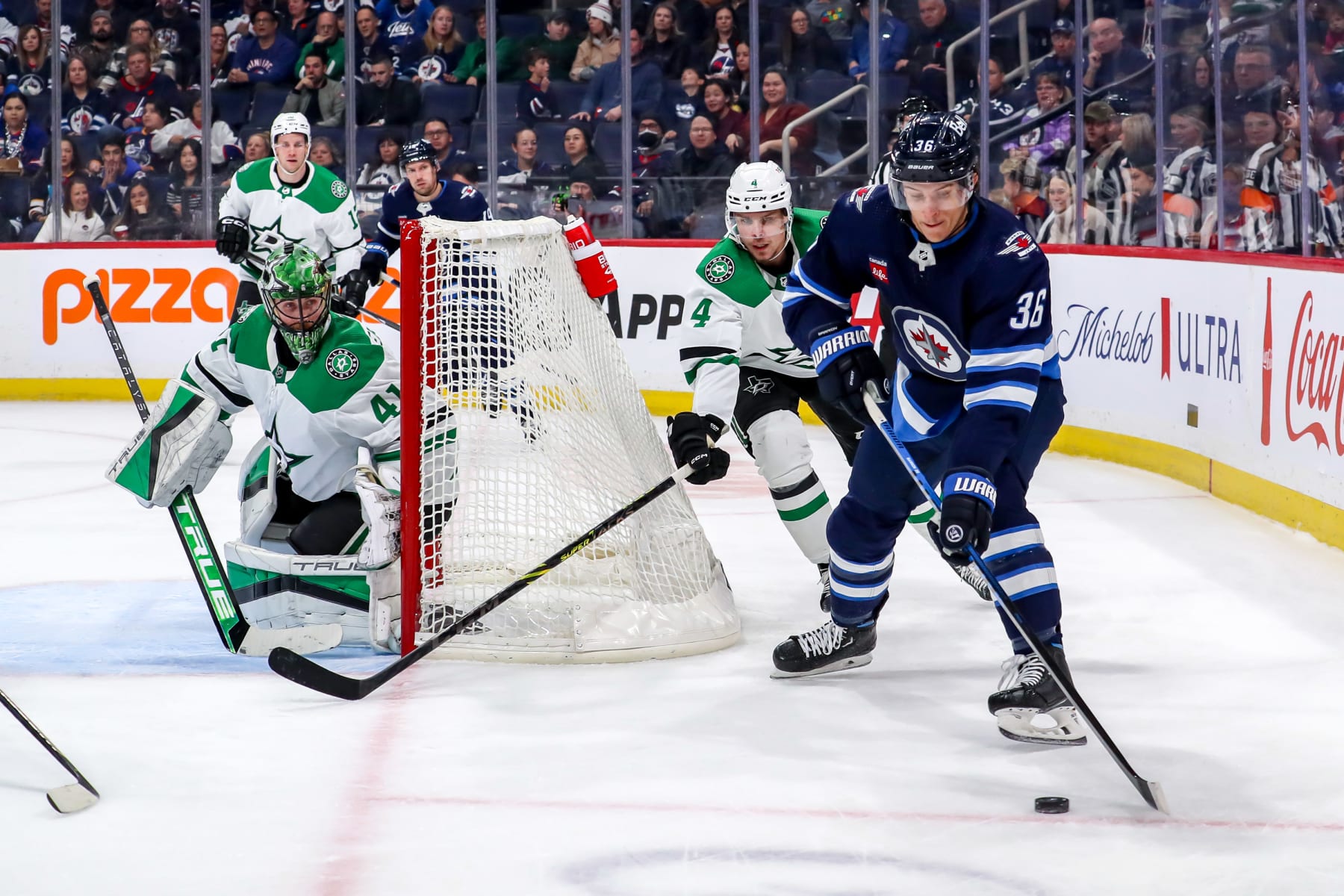 WINNIPEG, CANADA - NOVEMBER 11: Morgan Barron #36 of the Winnipeg Jets plays the puck around the net as goaltender Scott Wedgewood #41 and Miro Heiskanen #4 of the Dallas Stars defend during second period action at the Canada Life Centre on November 11, 2023 in Winnipeg, Manitoba, Canada. (Photo by Darcy Finley/NHLI via Getty Images)