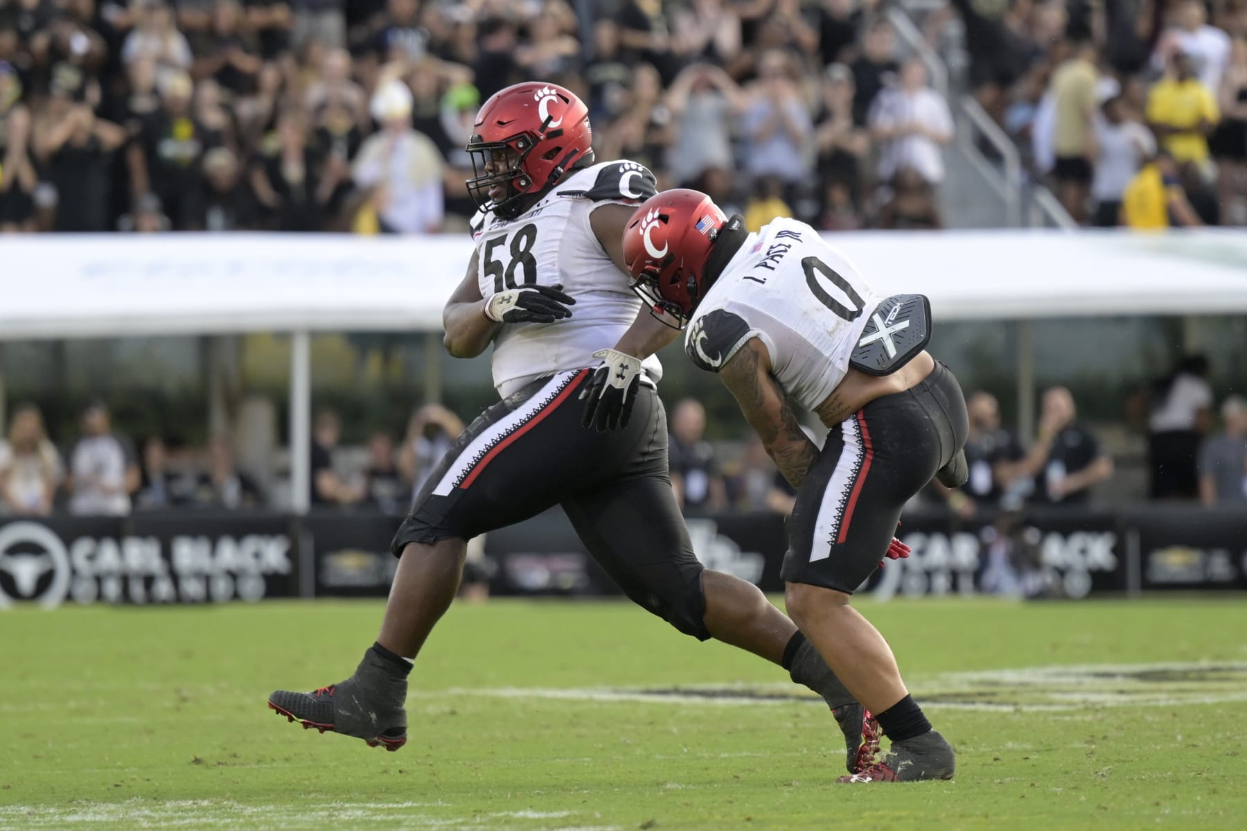 Cincinnati defensive lineman Dontay Corleone (58) and linebacker Ivan Pace Jr. (0) celebrate after Corleone recovered a fumble during the second half of an NCAA college football game against Central Florida, Saturday, Oct. 29, 2022, in Orlando, Fla. (AP Photo/Phelan M. Ebenhack)