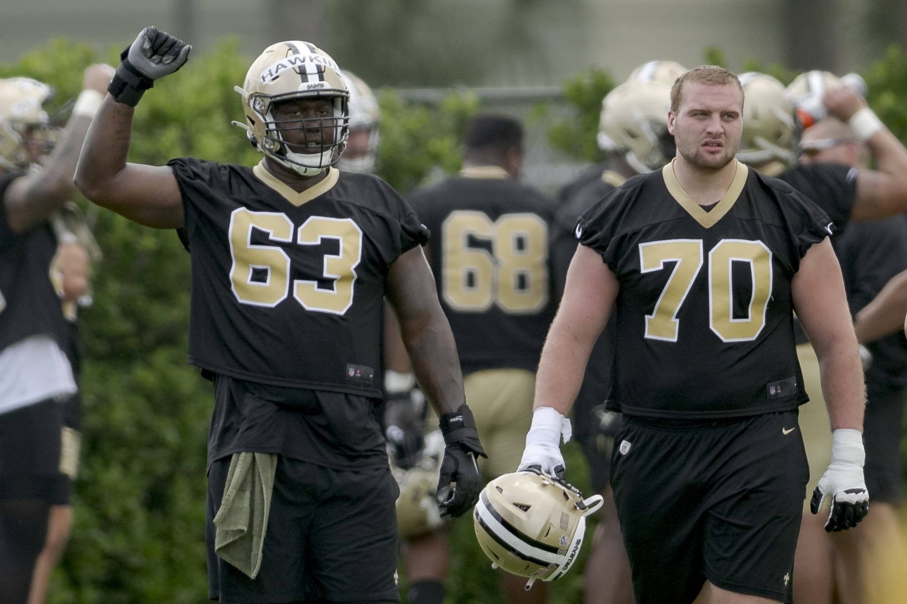 New Orleans Saints offensive tackle Jerald Hawkins (63) and offensive tackle Trevor Penning (70) watch a play during an NFL football practice in Metairie, La., Wednesday, June 15, 2022. (AP Photo/Matthew Hinton)