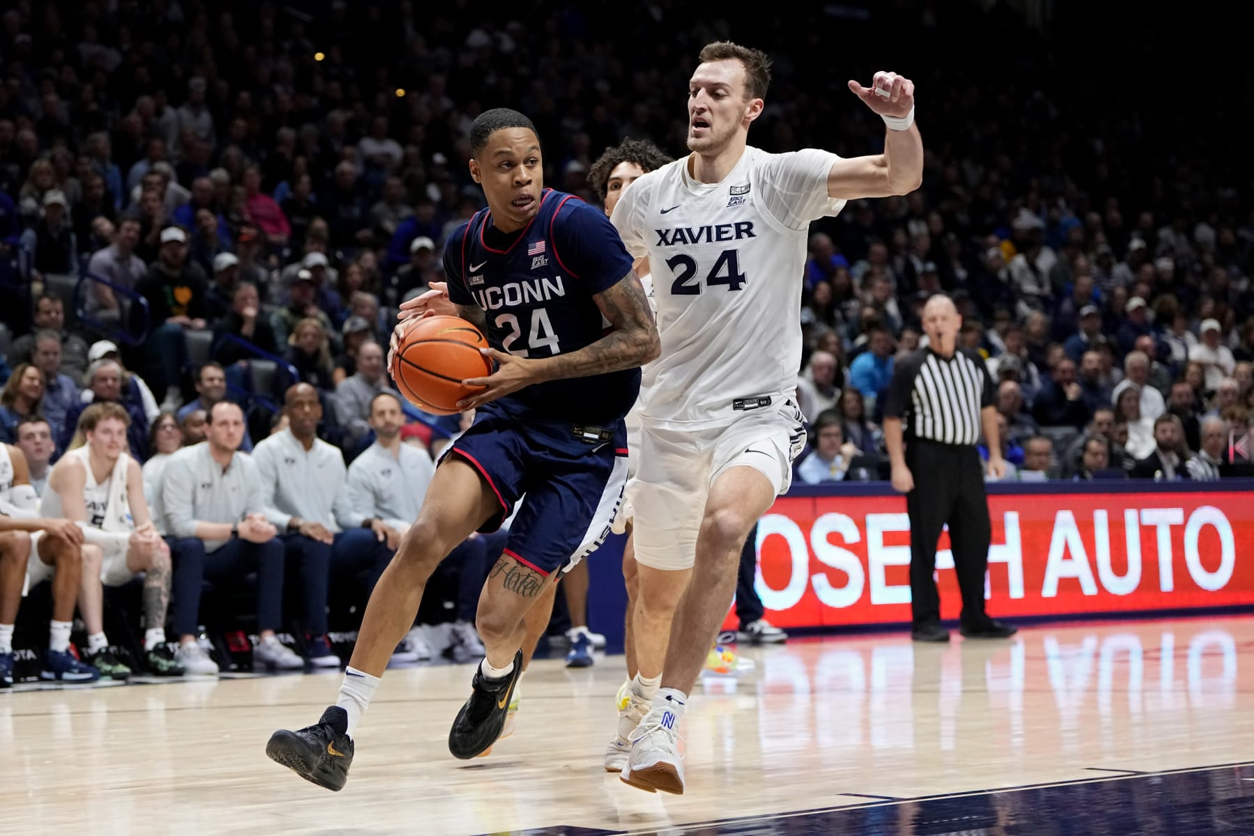 CINCINNATI, OHIO - DECEMBER 31: Jordan Hawkins #24 of the Connecticut Huskies dribbles the ball while being guarded by Jack Nunge #24 of the Xavier Musketeers in the first half at the Cintas Center on December 31, 2022 in Cincinnati, Ohio. (Photo by Dylan Buell/Getty Images)