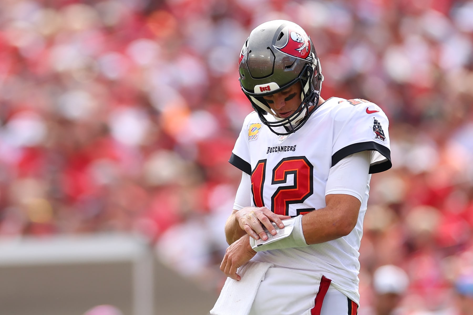 TAMPA, FLORIDA - OCTOBER 09: Tom Brady #12 of the Tampa Bay Buccaneers looks at his play sheet during the second half against the Atlanta Falcons at Raymond James Stadium on October 09, 2022 in Tampa, Florida. (Photo by Mike Ehrmann/Getty Images)
