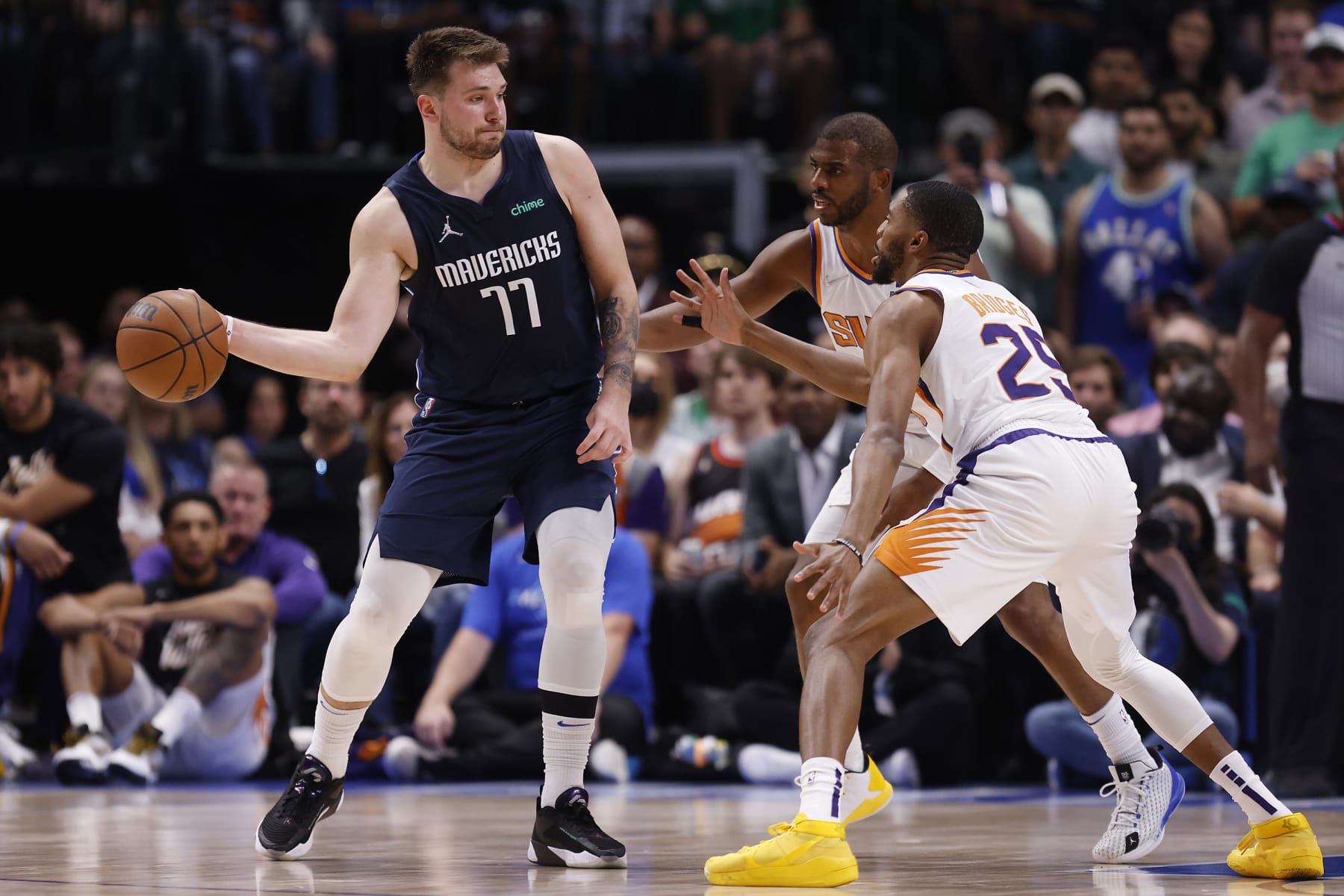DALLAS, TEXAS - MAY 12: Luka Doncic #77 of the Dallas Mavericks passes the ball against Mikal Bridges #25 of the Phoenix Suns and Chris Paul #3 of the Phoenix Suns in the second quarter of Game Six of the 2022 NBA Playoffs Western Conference Semifinals at American Airlines Center on May 12, 2022 in Dallas, Texas. NOTE TO USER: User expressly acknowledges and agrees that, by downloading and/or using this photograph, User is consenting to the terms and conditions of the Getty Images License Agreement. (Photo by Ron Jenkins/Getty Images)