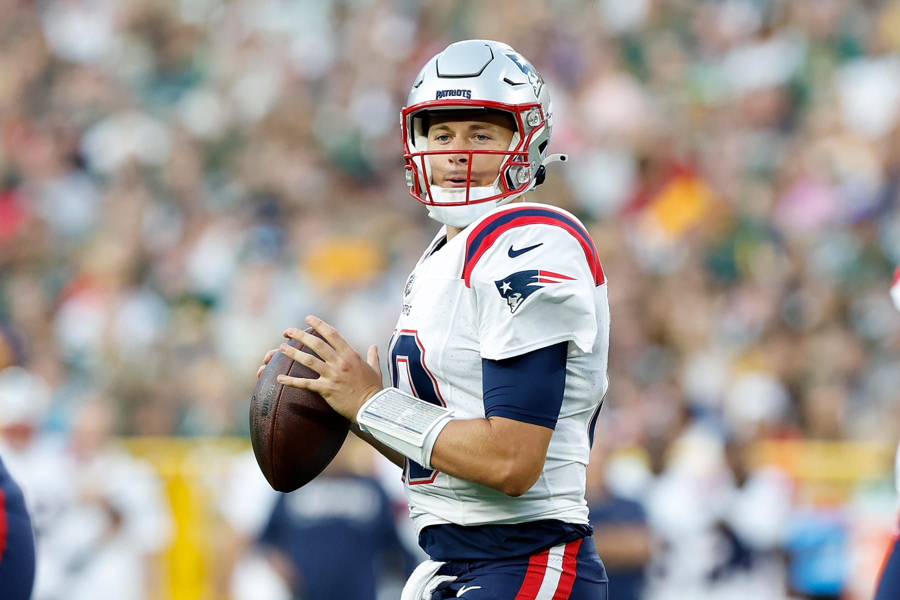 GREEN BAY, WISCONSIN - AUGUST 19: Mac Jones #10 of the New England Patriots drops back to pass during the first quarter against the Green Bay Packers in a preseason game at Lambeau Field on August 19, 2023 in Green Bay, Wisconsin. (Photo by John Fisher/Getty Images)