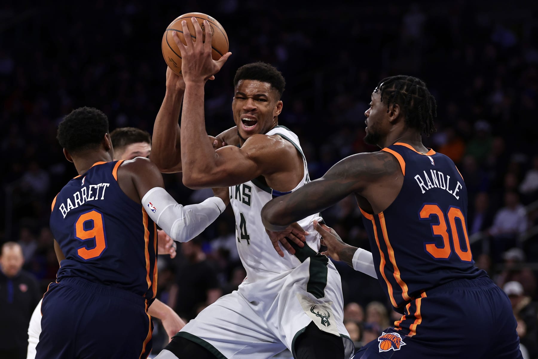 Milwaukee Bucks forward Giannis Antetokounmpo drives to the basket between New York Knicks forward Julius Randle (30) and RJ Barrett (9) during the second half of an NBA basketball game Wednesday, Nov. 30, 2022, in New York. The Bucks won 109-103. (AP Photo/Adam Hunger)