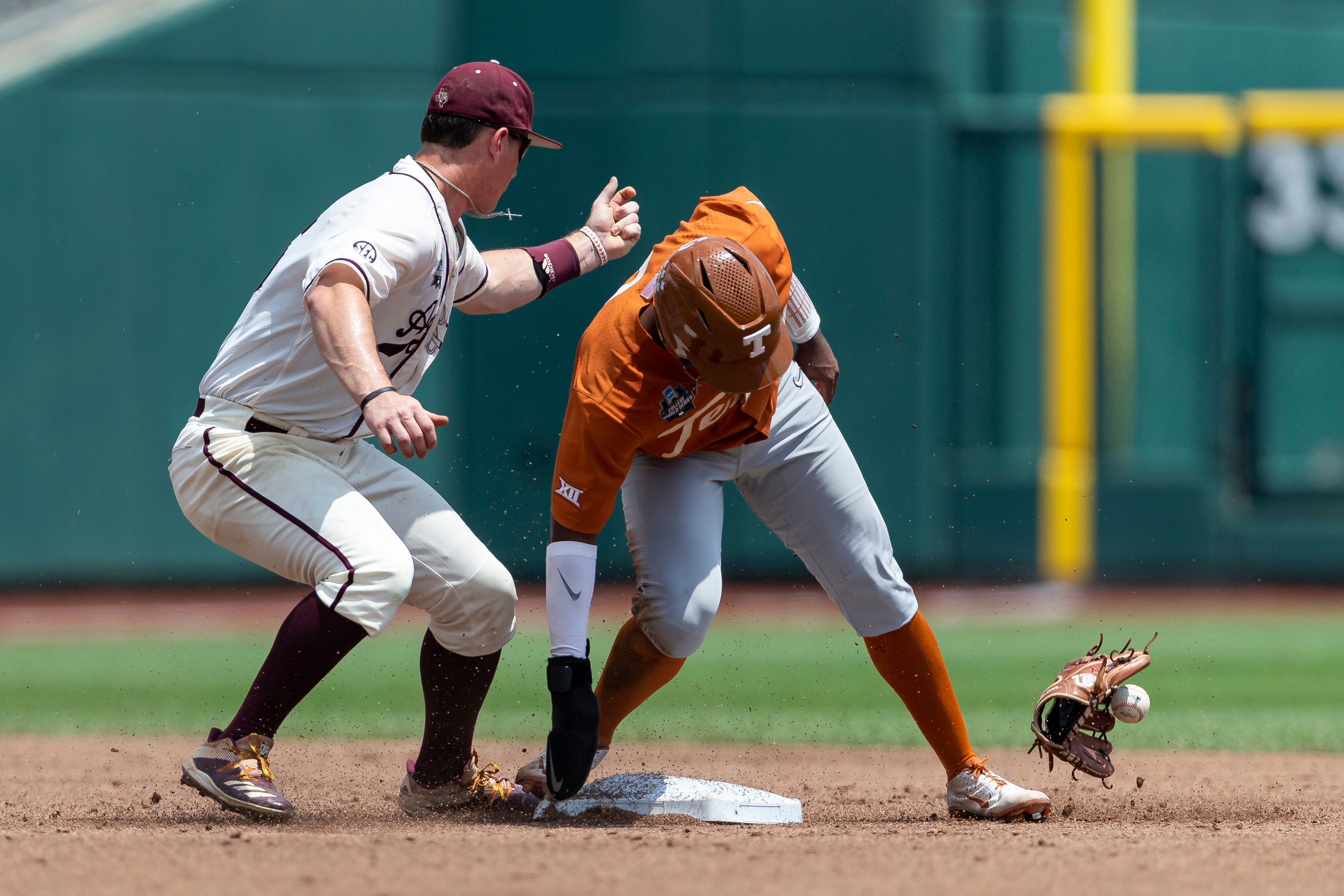Texas' Dylan Campbell, right, slides into second base on a steal, knocking the glove and ball off Texas A&M second baseman Ryan Targac's hand, in the first inning during an NCAA College World Series baseball game Sunday, June 19, 2022, in Omaha, Neb. (AP Photo/John Peterson) Texas' Dylan Campbell, right, slides into second base on a steal, knocking the glove and ball off Texas A&M second baseman Ryan Targac's hand, in the first inning during an NCAA College World Series baseball game Sunday, June 19, 2022, in Omaha, Neb. (AP Photo/John Peterson)