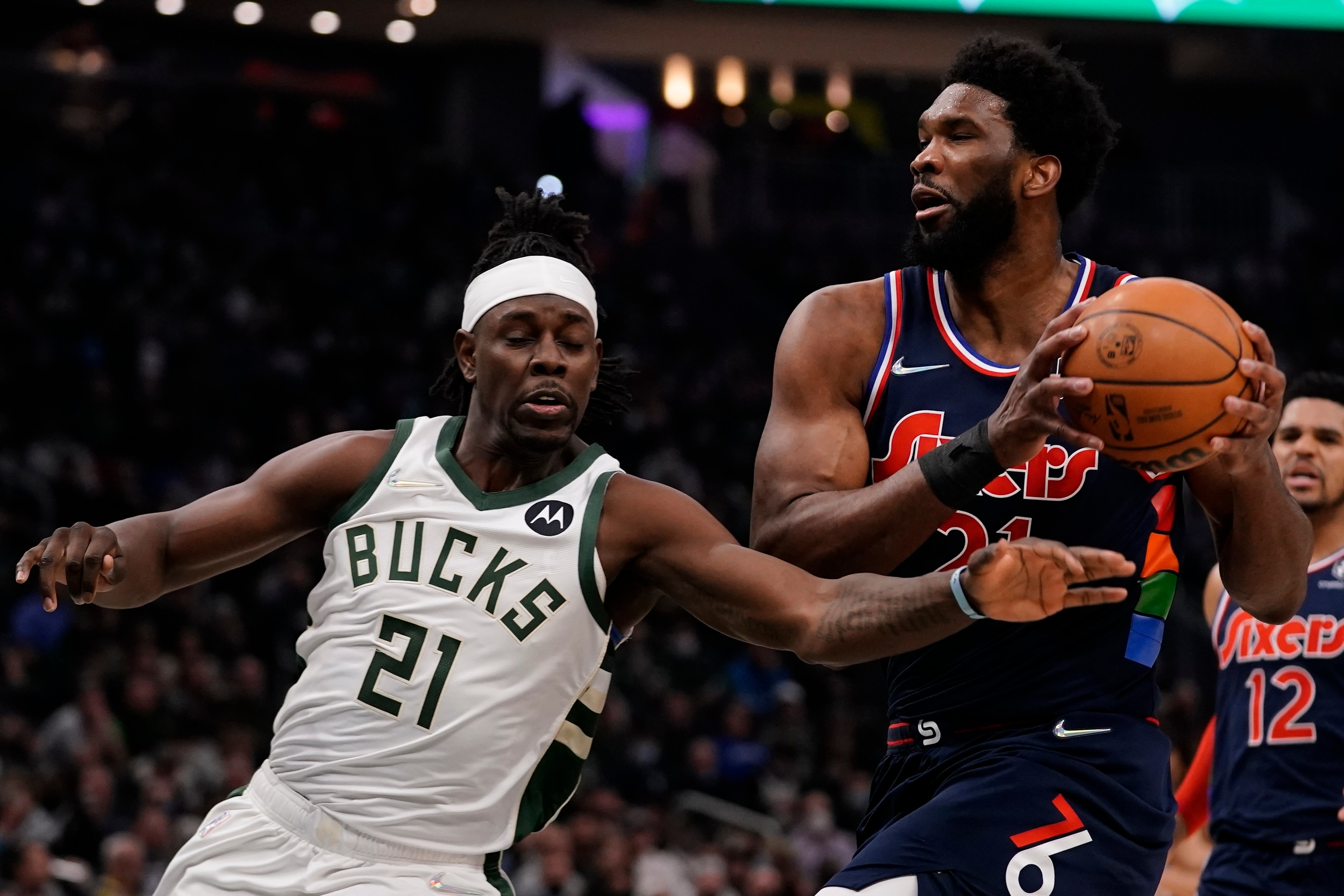 Philadelphia 76ers' Joel Embiid drives past Milwaukee Bucks' Jrue Holiday during the first half of an NBA basketball game Thursday, Feb. 17, 2022, in Milwaukee. (AP Photo/Morry Gash)