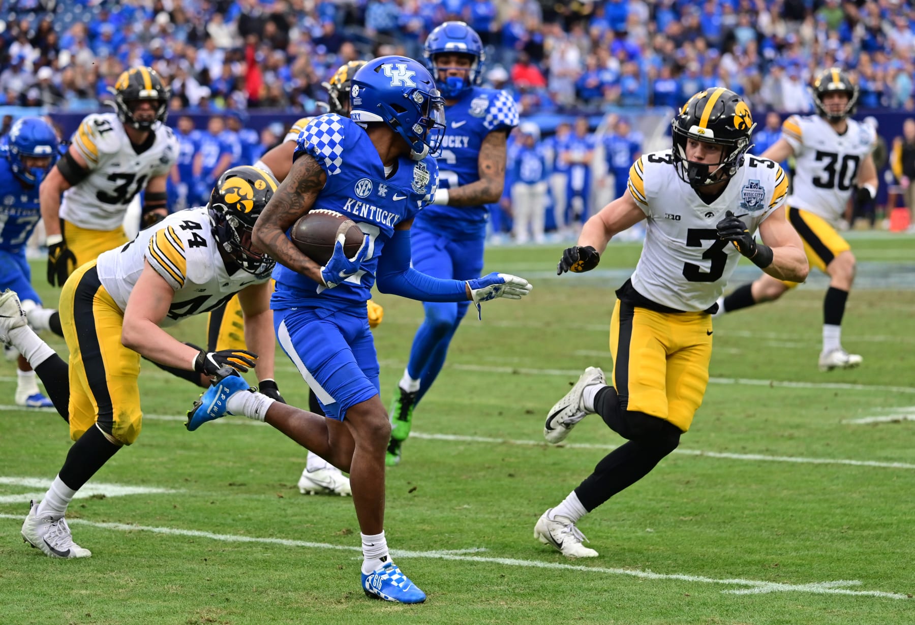 NASHVILLE, TN - DECEMBER 31: Kentucky wide receiver Marion Brown (2) runs the ball as Iowa linebacker Seth Benson (44) and Iowa left cornerback Cooper DeJean (3) defend during the TransPerfect Music City Bowl game between the Kentucky Wildcats and the Iowa Hawkeyes on December 31, 2022, at Nissan Stadium in Nashville, TN (Photo by Keith Gillett/Icon Sportswire via Getty Images)