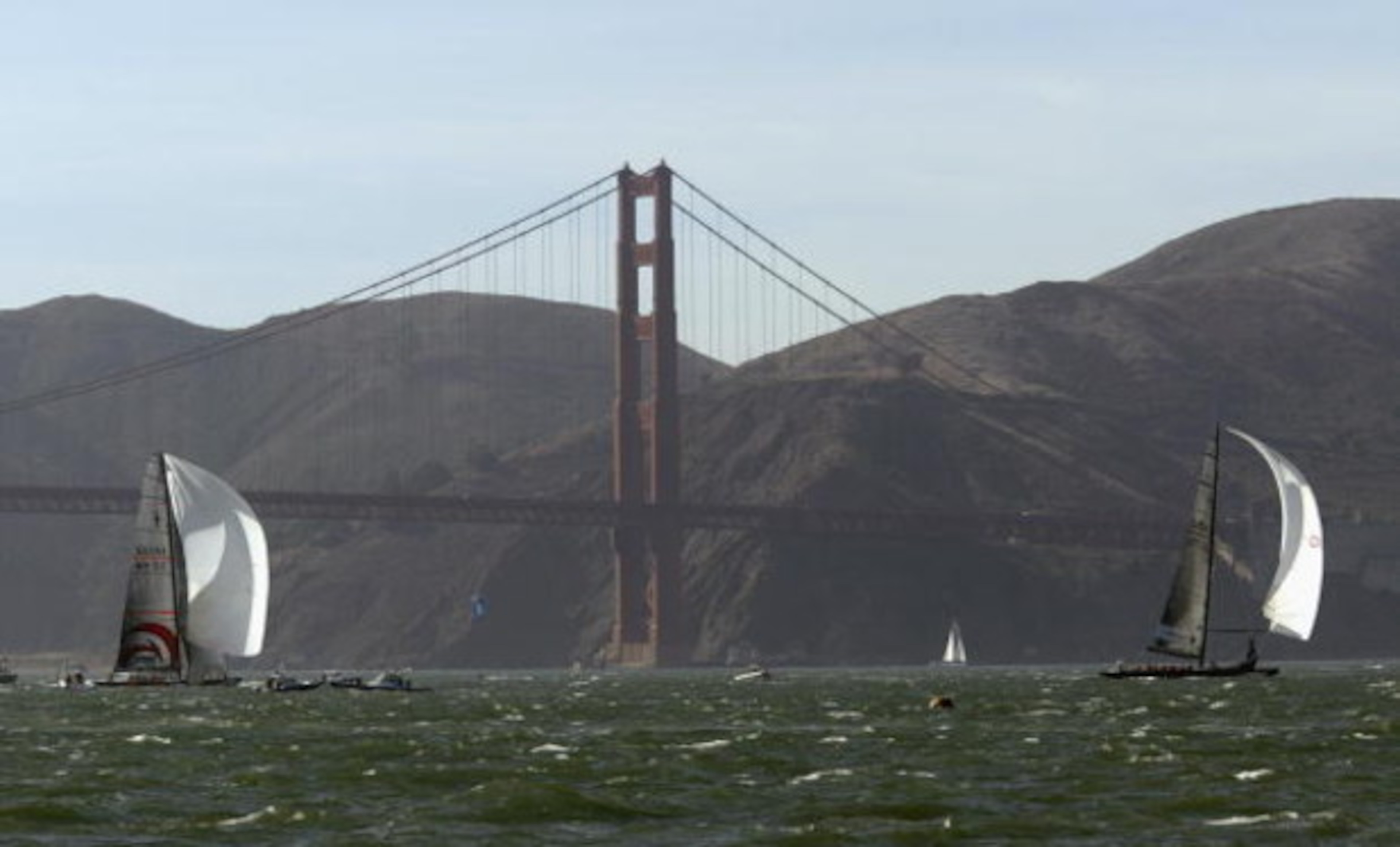 SAN FRANCISCO - SEPTEMBER 16:  Swiss Team Alinghi headed by Ernesto Bertarelli (left) and Oracle BMW Racing team headed by Larry Ellison race in front of the Golden Gate Bridge during the Moet Cup in the San Francisco Bay on September 16, 2003 in San Fran