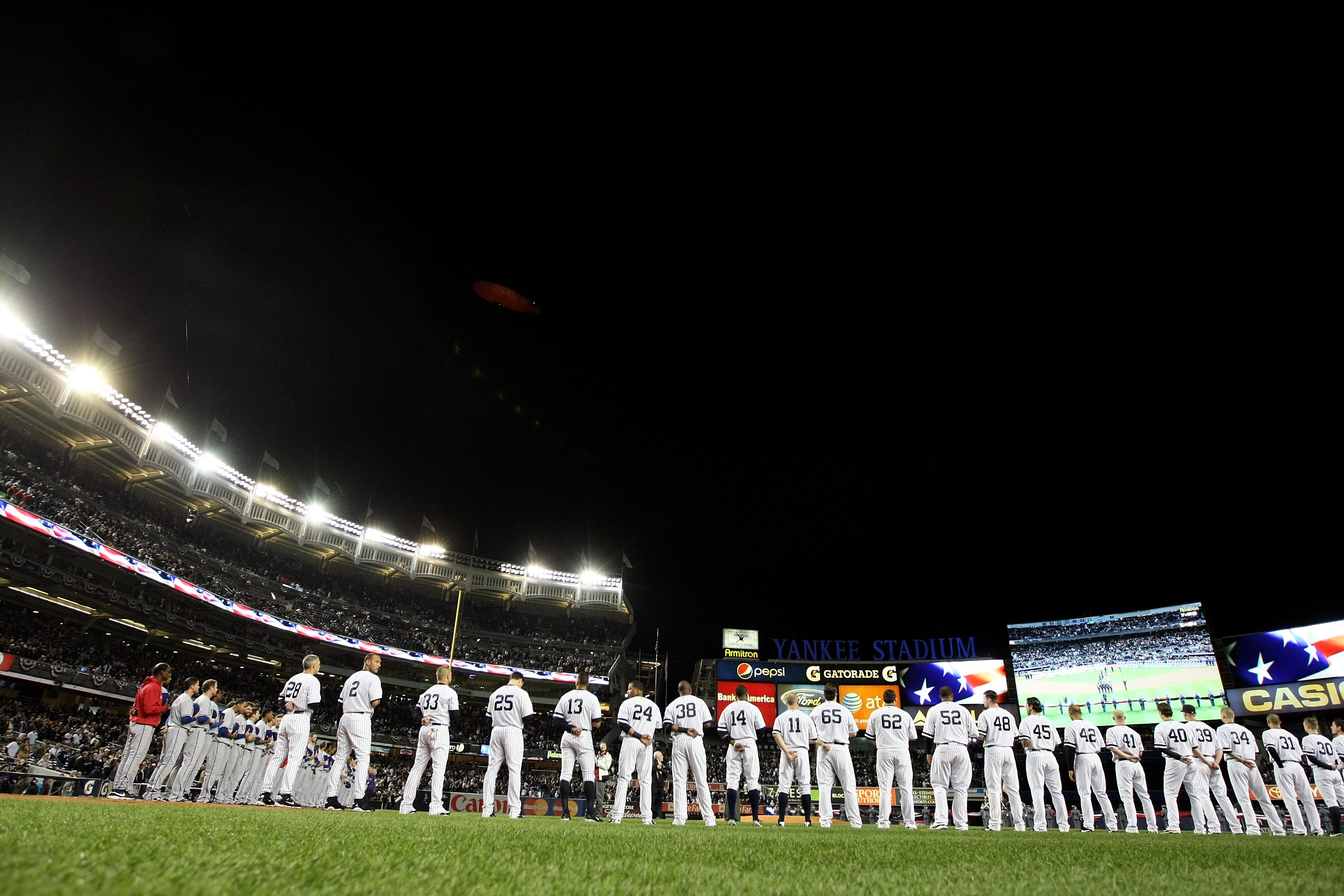 NEW YORK - OCTOBER 18:  The New York Yankees and the Texas Rangers line up on the foul lines during the performance of the National Anthem prior to playing Game Three of the ALCS during the 2010 MLB Playoffs at Yankee Stadium on October 18, 2010 in New Yo
