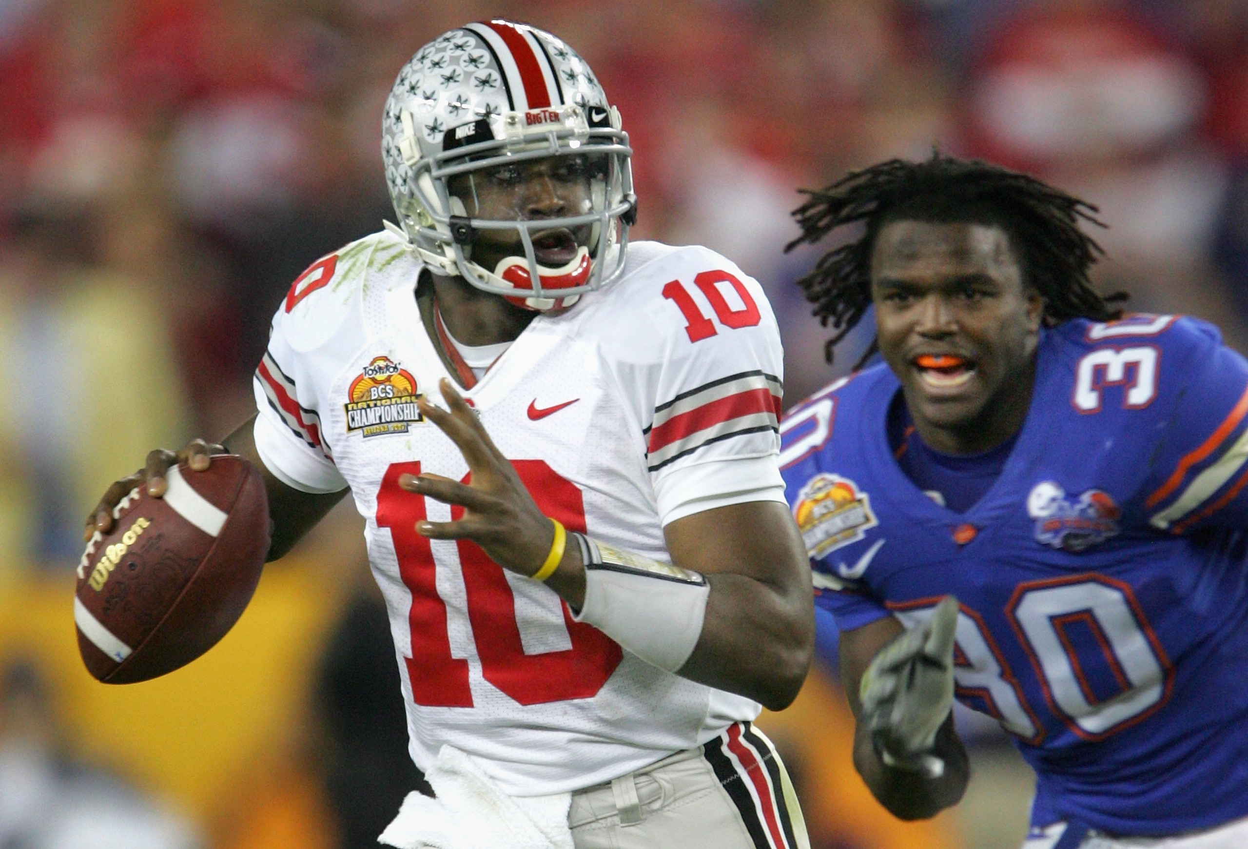 GLENDALE, AZ - JANUARY 08:  Quarterback Troy Smith #10 of the Ohio State Buckeyes scrambles under pressure from Earl Everett #30 of the Florida Gators during the 2007 Tostitos BCS National Championship Game at the University of Phoenix Stadium on January 