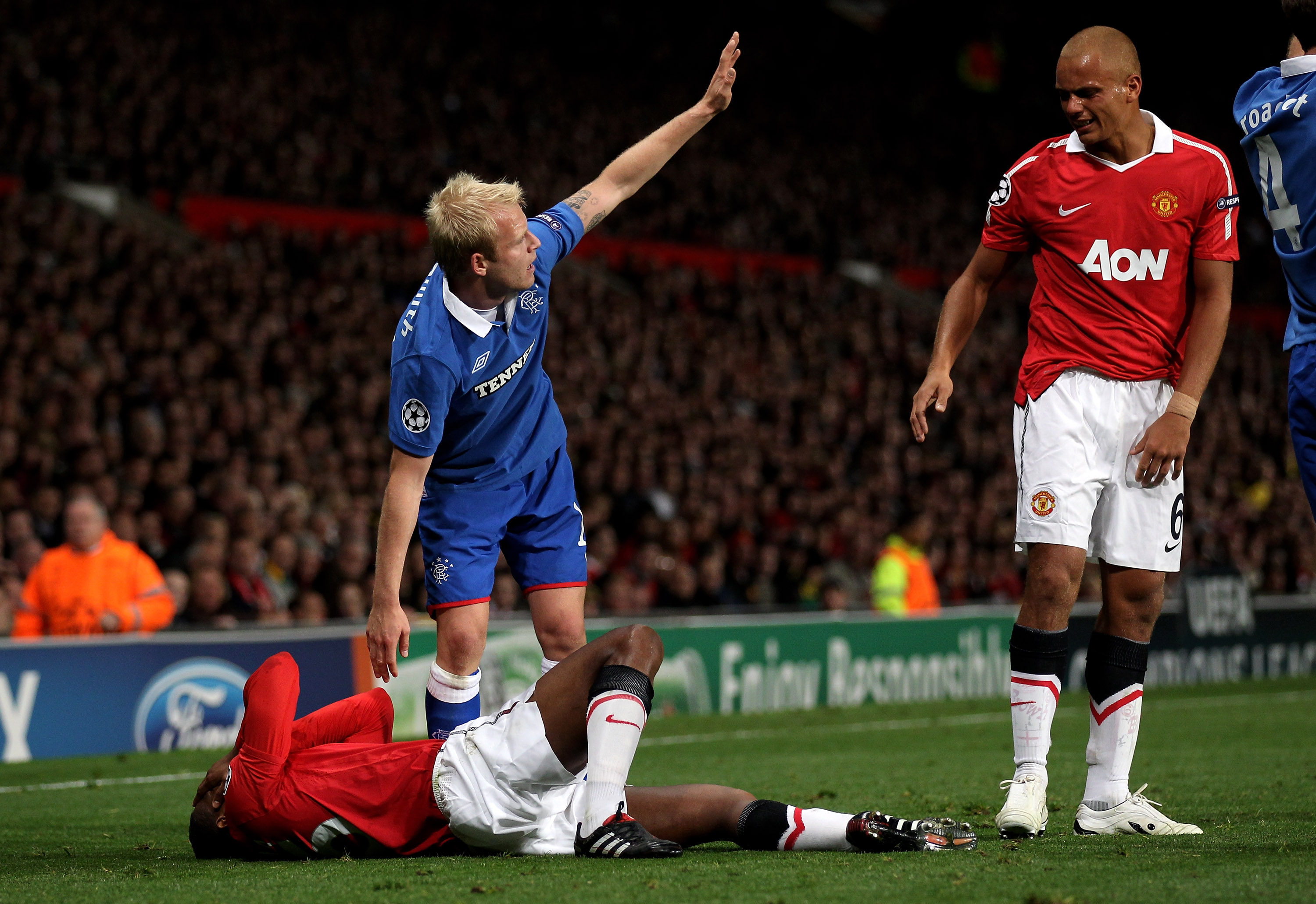 MANCHESTER, ENGLAND - SEPTEMBER 14:  Steven Naismith of Rangers checks on the injured Antonio Valencia of Manchester United during the UEFA Champions League Group C match between Manchester United and Rangers at Old Trafford on September 14, 2010 in Manch