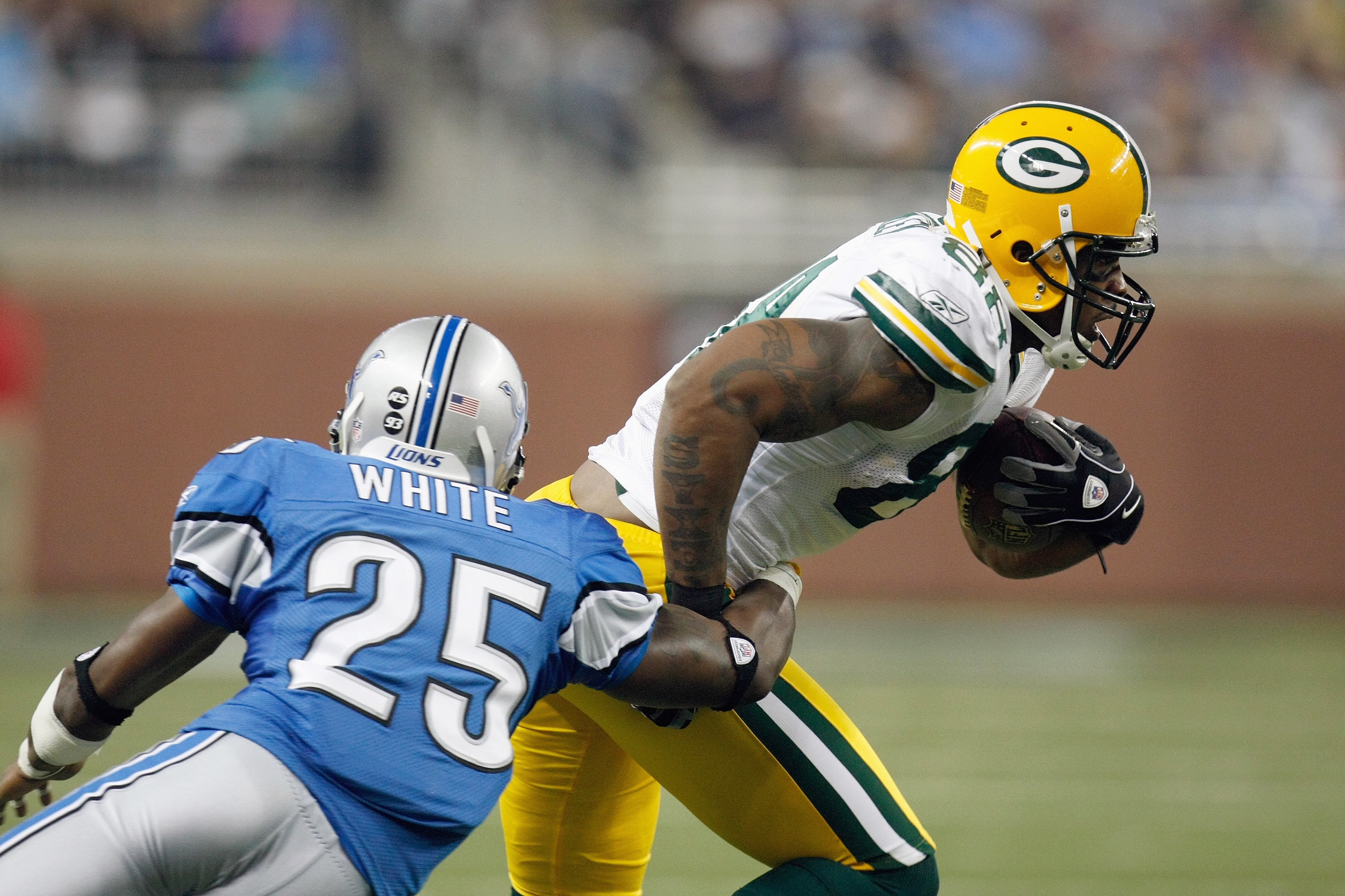 DETROIT , MI - NOVEMBER 26:  Jermichael Finley #88 of the Green Bay Packers carries the ball as he is tackled by Marvin White #25 of the Detroit Lions on November 26, 2009 at Ford Field in Detroit, Michigan. Green Bay won the game 34-12. (Photo by Gregory