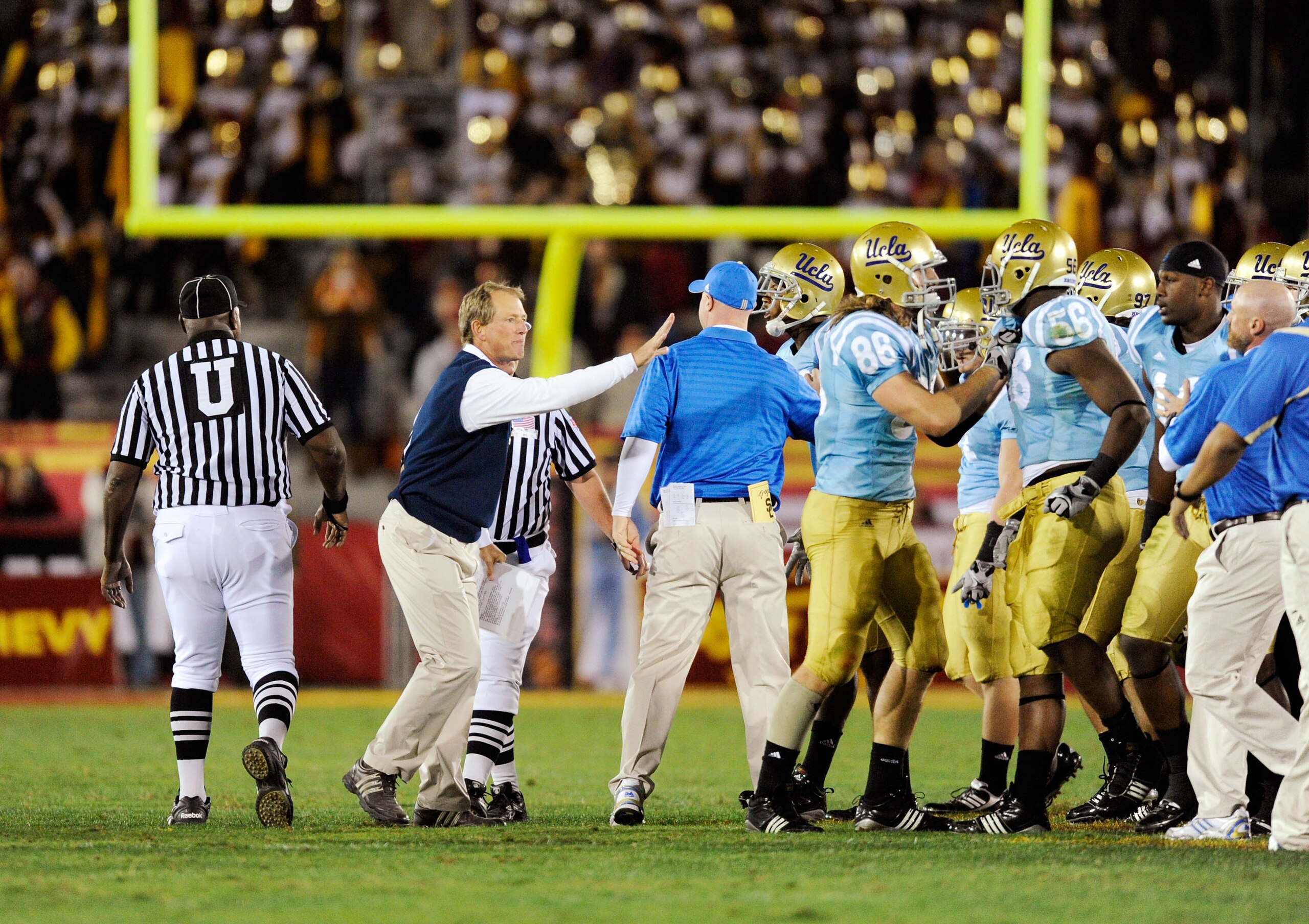 LOS ANGELES, CA - NOVEMBER 28:  Rick Neuheisel head coach of the UCLA Bruins restrains his players after they nearly had an all-out fight with USC Trojans at the end of the NCAA college football game at Los Angeles Memorial Coliseum on November 28, 2009 i