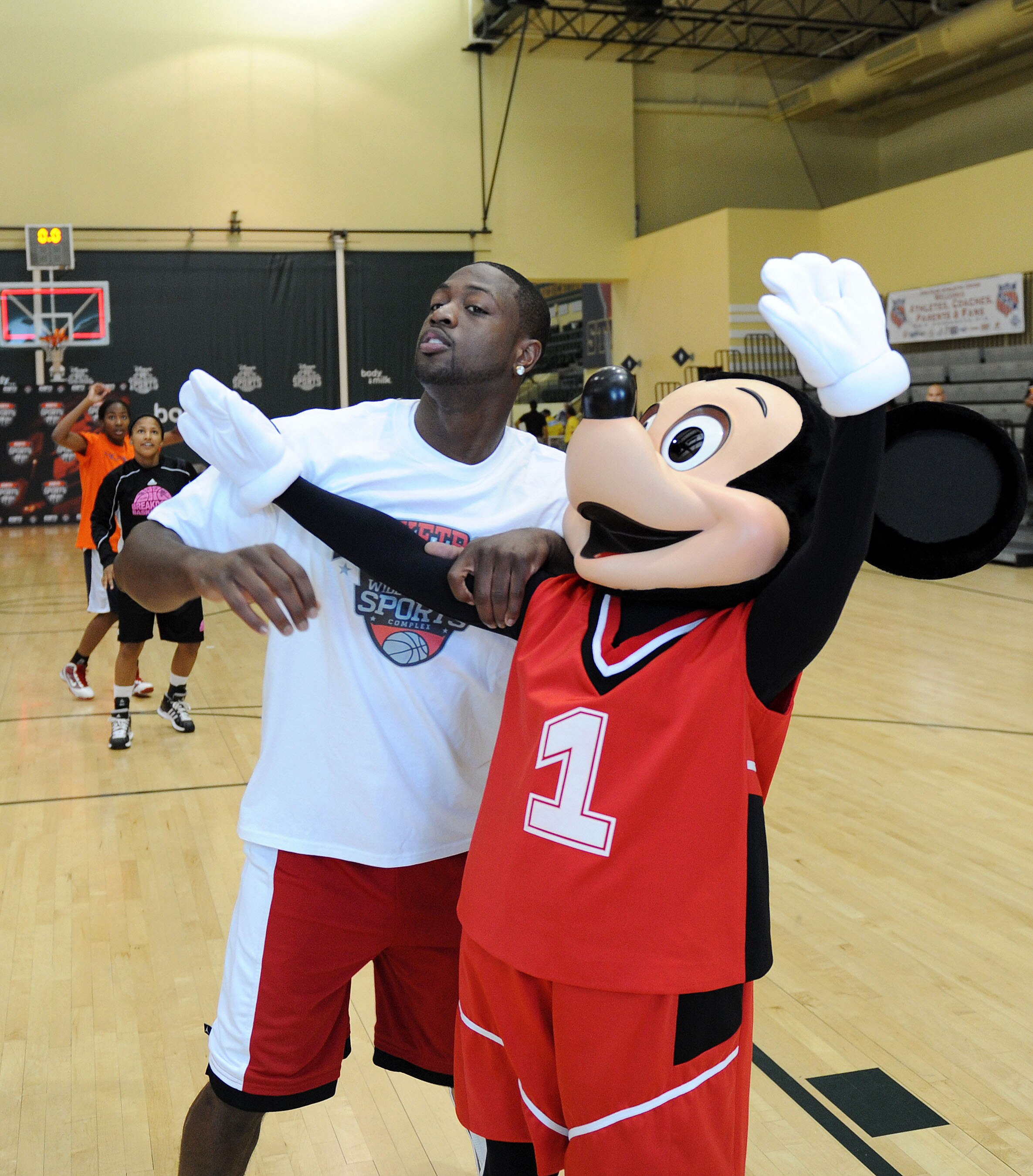 LAKE BUENA VISTA, FL - JULY 11:  In this handout image provided by Walt Disney Studios, Miami Heat guard Dwyane Wade battles for position with Mickey Mouse July 11, 2010 during a short 3-on-3 game at the ESPN Wide World of Sports complex in Lake Buena Vis