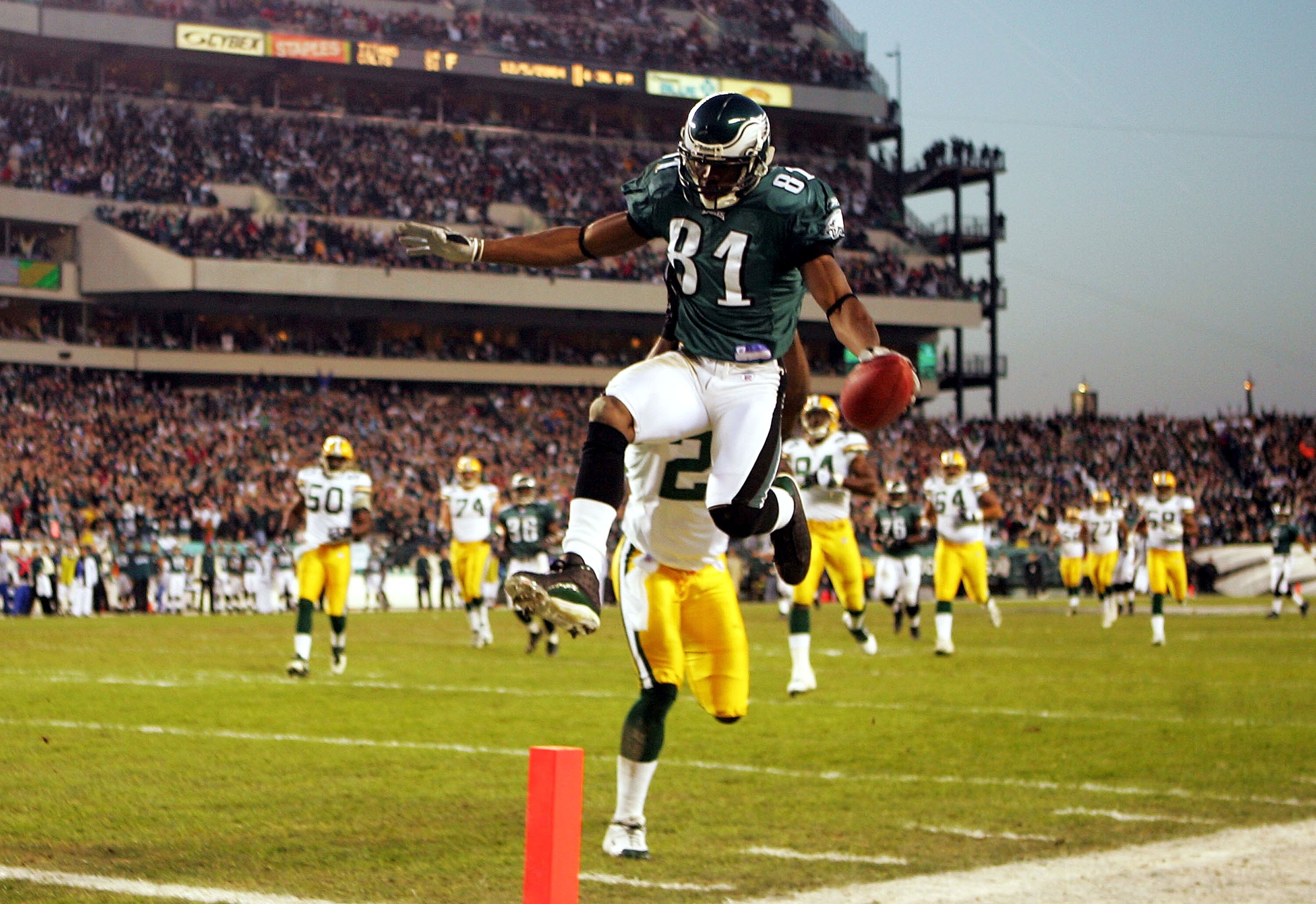 PHILADELPHIA - DECEMBER 5:  Wide Receiver Terrell Owens #81 of the Philadelphia Eagles leaps into the end zone in front of safety Bhawoh Jue #21 of the Green Bay Packers in the first quarter to give the Eagles a 6-0 lead at Lincoln Financial Field on Dece