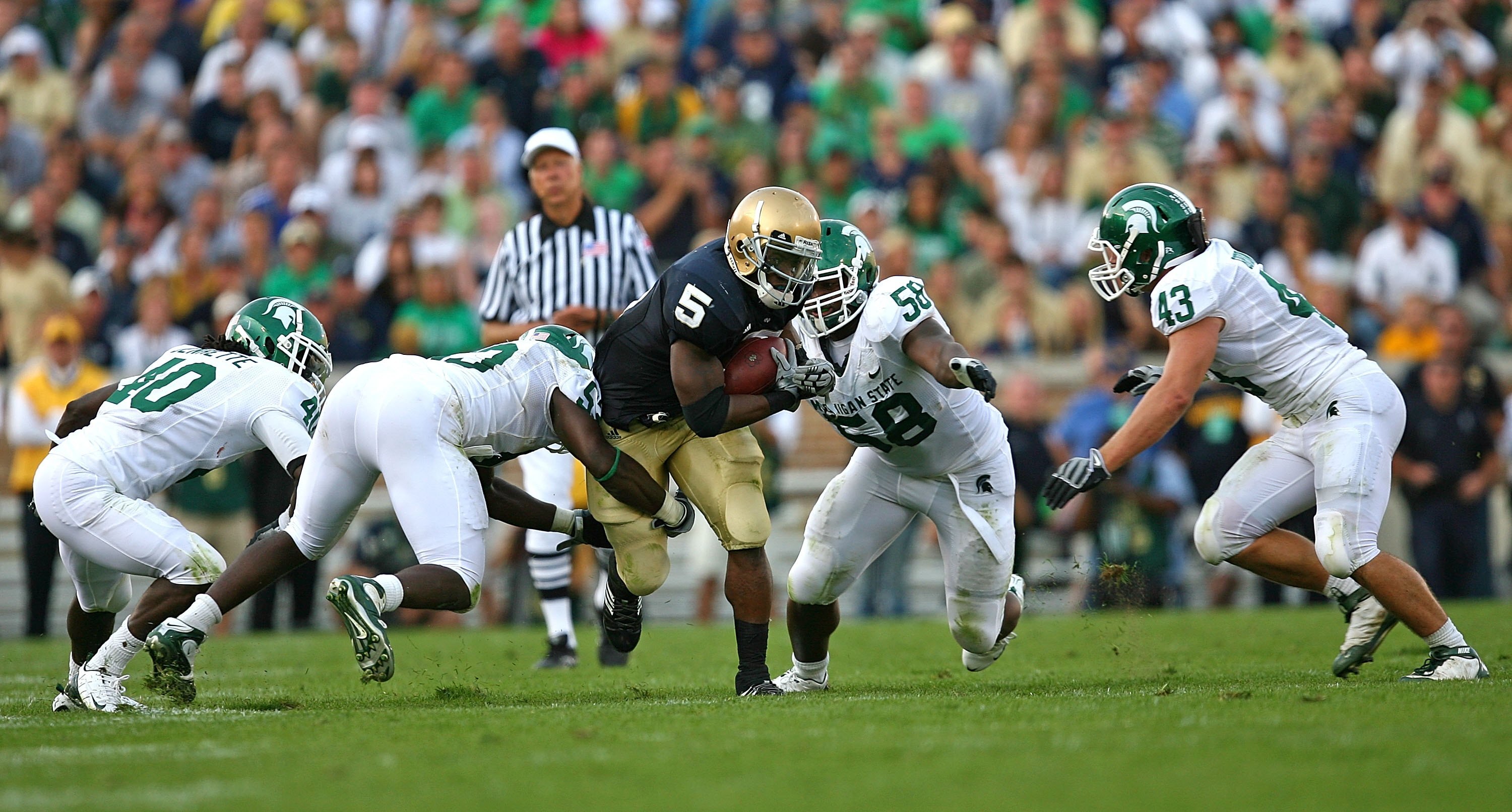 SOUTH BEND, IN - SETPEMBER 19: Armando Allen #5 of the Notre Dame Fighting Irish runs against (L-R) Roderick Jenrette #40, Greg Jones #53, Trevor Anderson #58 and Eric Gordon #43 of the Michigan State Spartans on September 19, 2009 at Notre Dame Stadium i