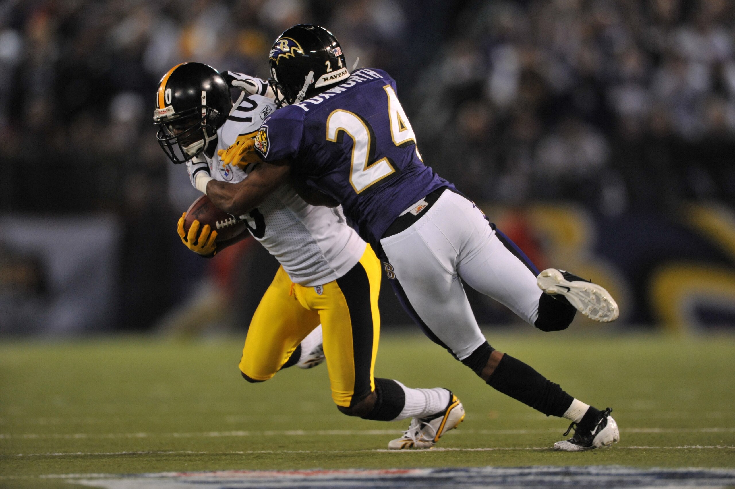 BALTIMORE - NOVEMBER 29:  Domonique Foxworth #24 of the Baltimore Ravens tackles Santonio Holmes #10 of the Pittsburgh Steelers at M&T Bank Stadium on November 29, 2009 in Baltimore, Maryland. The Ravens defeated the Steelers 20-17. (Photo by Larry French