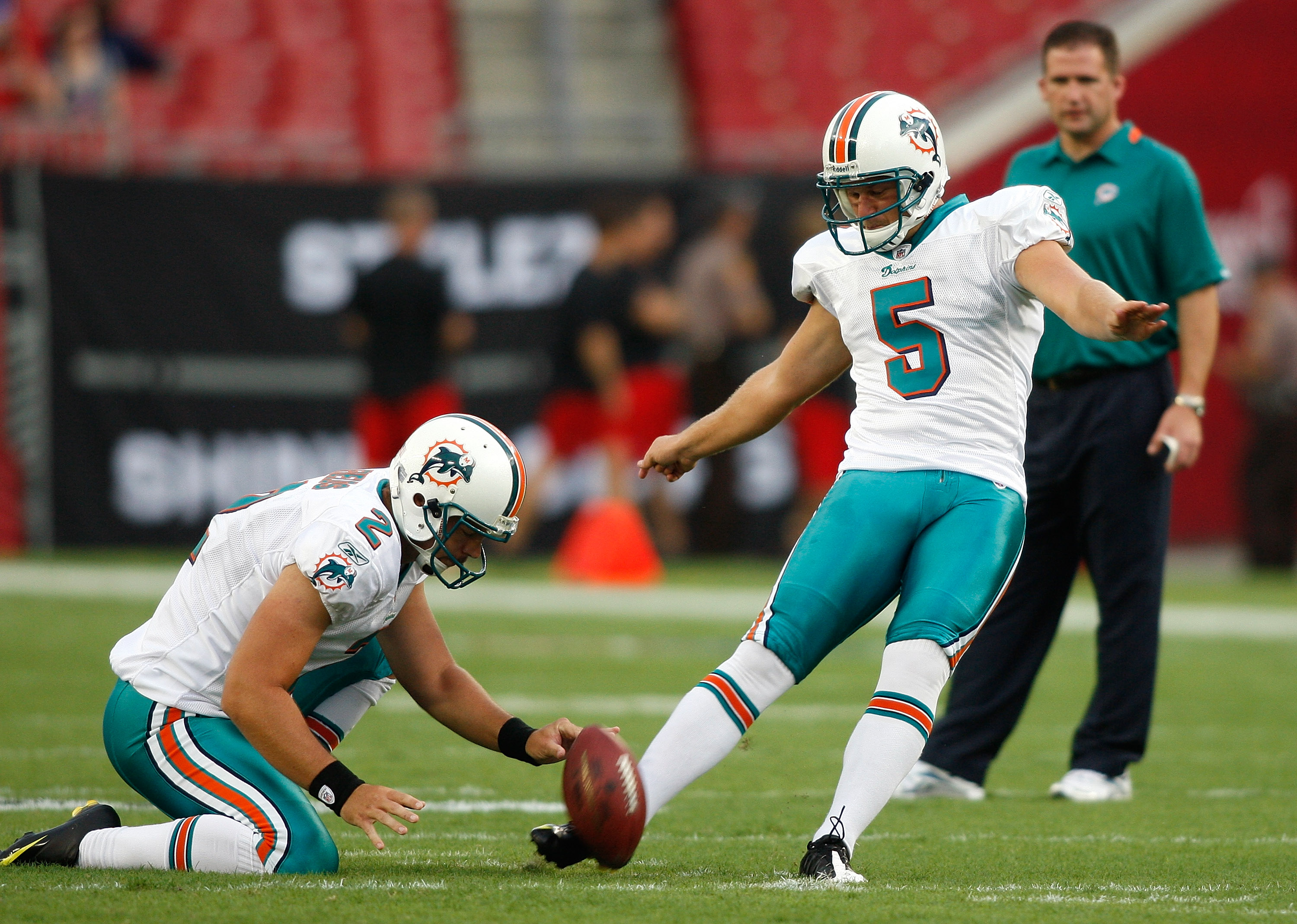 TAMPA, FL - AUGUST 27:  Kicker Dan Carpenter #5 of the Miami Dolphins kicks a field goal out of the hold of Brandon Fields #2 during pregame against the Tampa Bay Buccaneers at Raymond James Stadium on August 27, 2009 in Tampa, Florida.  (Photo by J. Meri