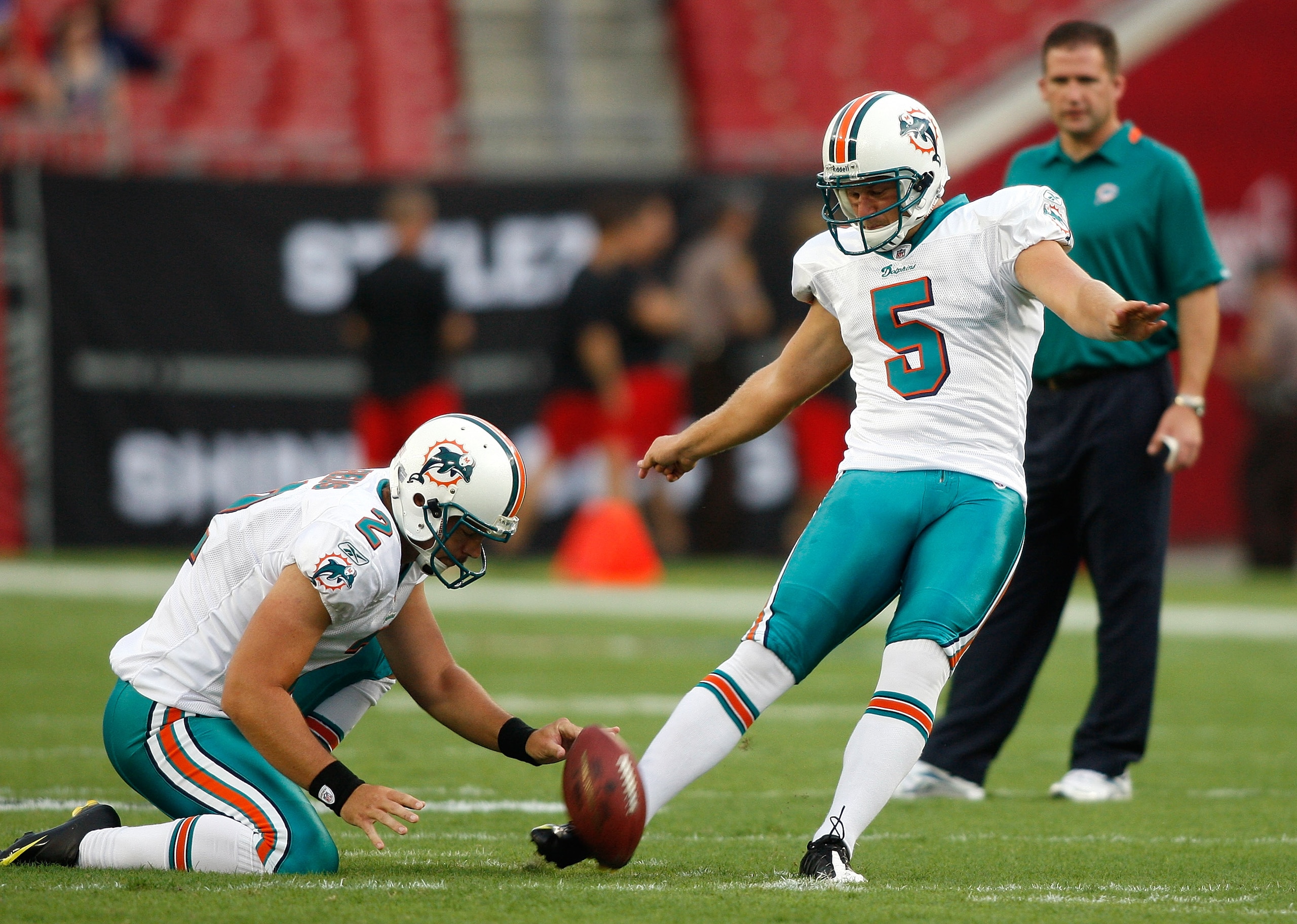 TAMPA, FL - AUGUST 27:  Kicker Dan Carpenter #5 of the Miami Dolphins kicks a field goal out of the hold of Brandon Fields #2 during pregame against the Tampa Bay Buccaneers at Raymond James Stadium on August 27, 2009 in Tampa, Florida.  (Photo by J. Meri