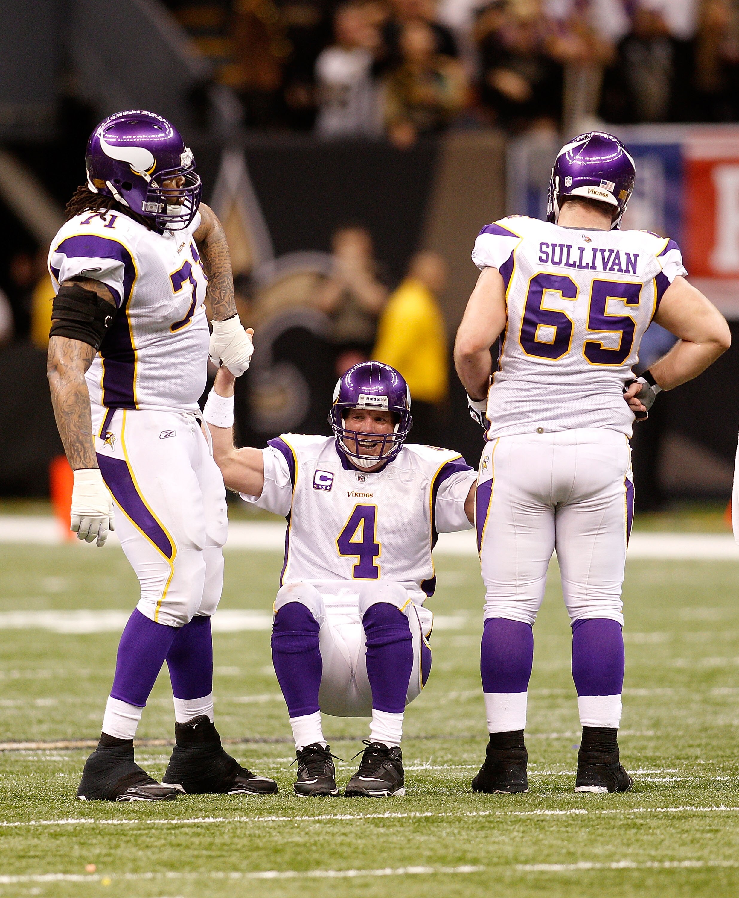 NEW ORLEANS - JANUARY 24:  Brett Favre #4 of  the Minnesota Vikings is helped up by teammates Phil Loadholt #71 and John Sullivan #65 after he took a hard hit in the second half against the New Orleans Saints during the NFC Championship Game at the Louisi
