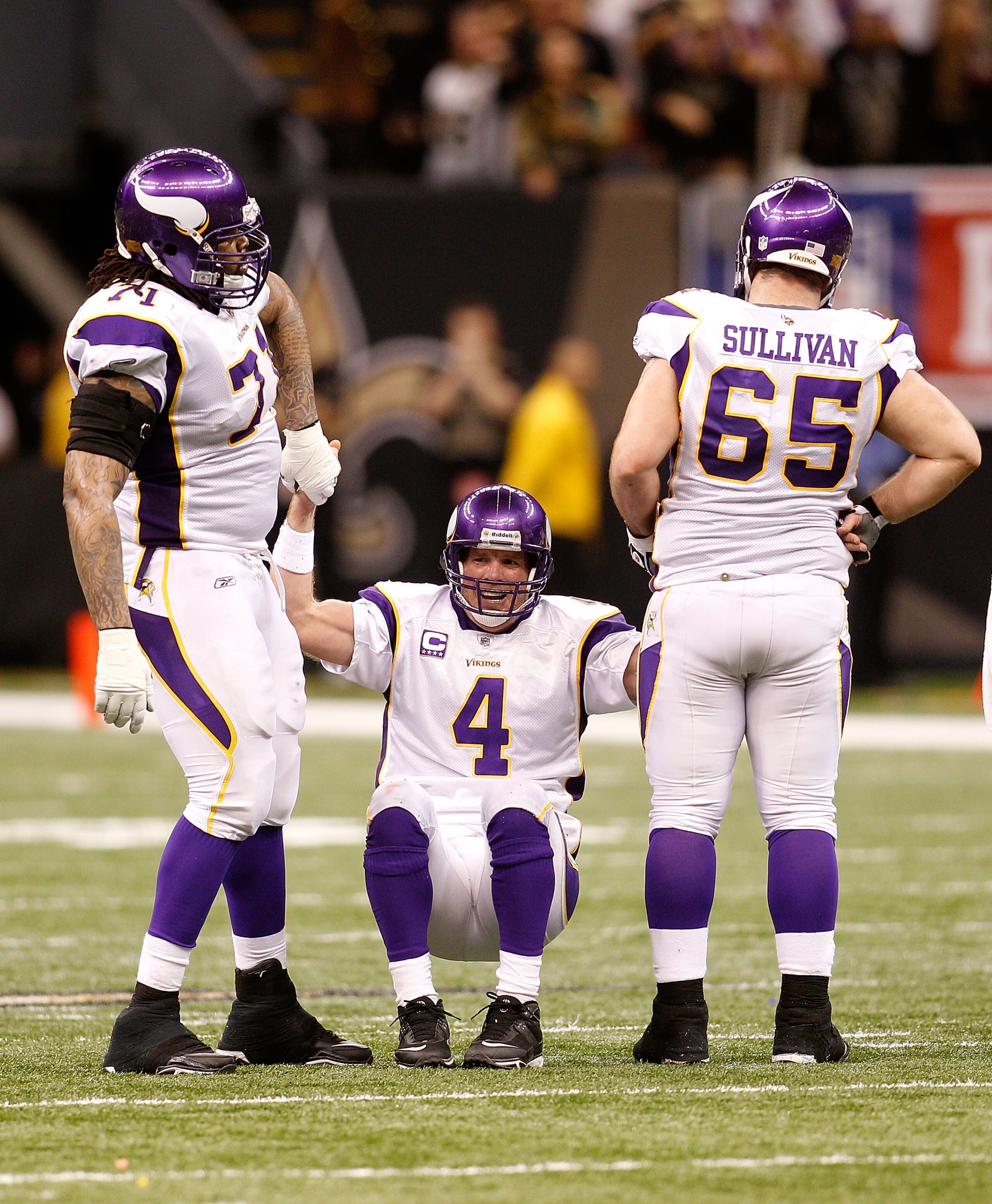 NEW ORLEANS - JANUARY 24:  Brett Favre #4 of  the Minnesota Vikings is helped up by teammates Phil Loadholt #71 and John Sullivan #65 after he took a hard hit in the second half against the New Orleans Saints during the NFC Championship Game at the Louisi