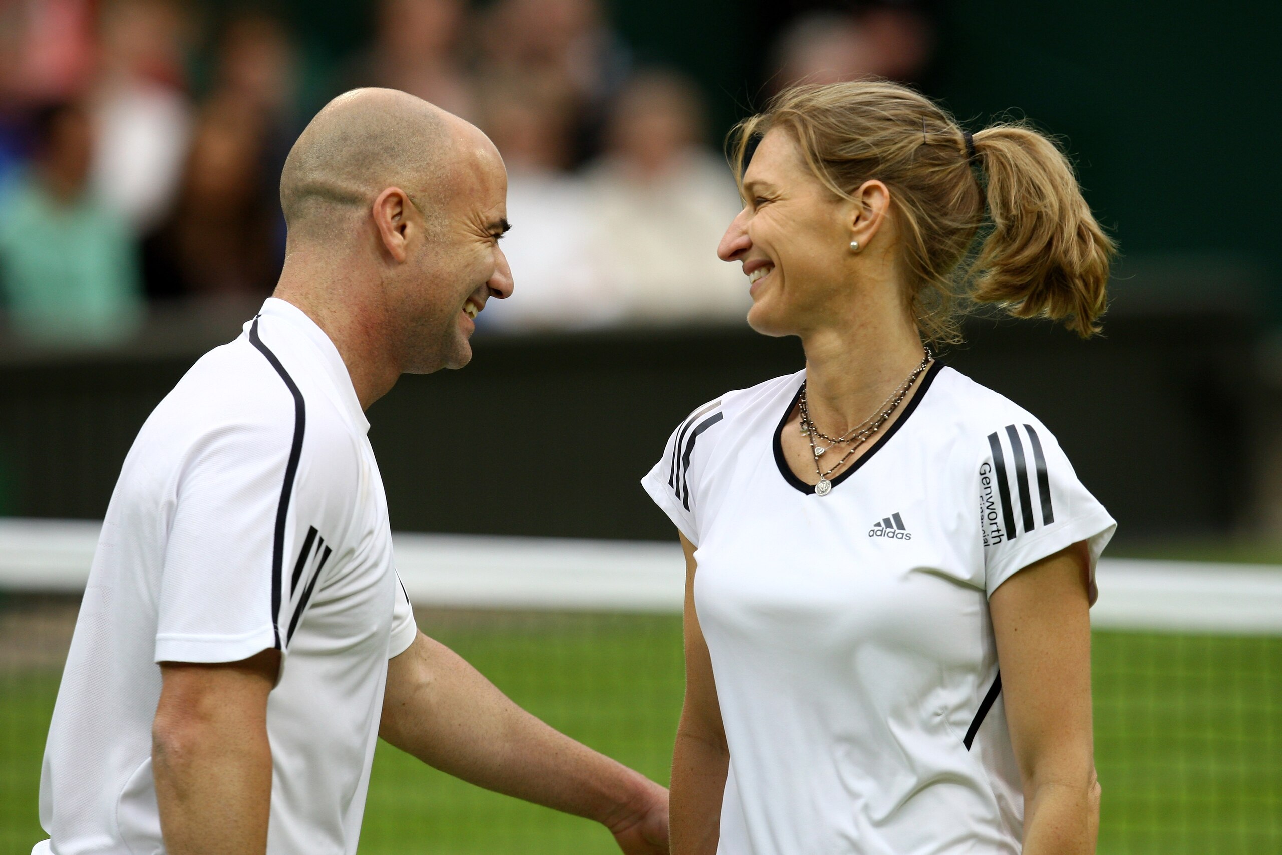 LONDON, ENGLAND - MAY 17:  Andre Agassi (L) and Steffi Graf (R) share a joke during the Mixed Doubles match against Tim Henman and Kim Clijsters  during the 'Centre Court Celebration' at Wimbledon on May 17, 2009 in London, England.  (Photo by Paul Gilham