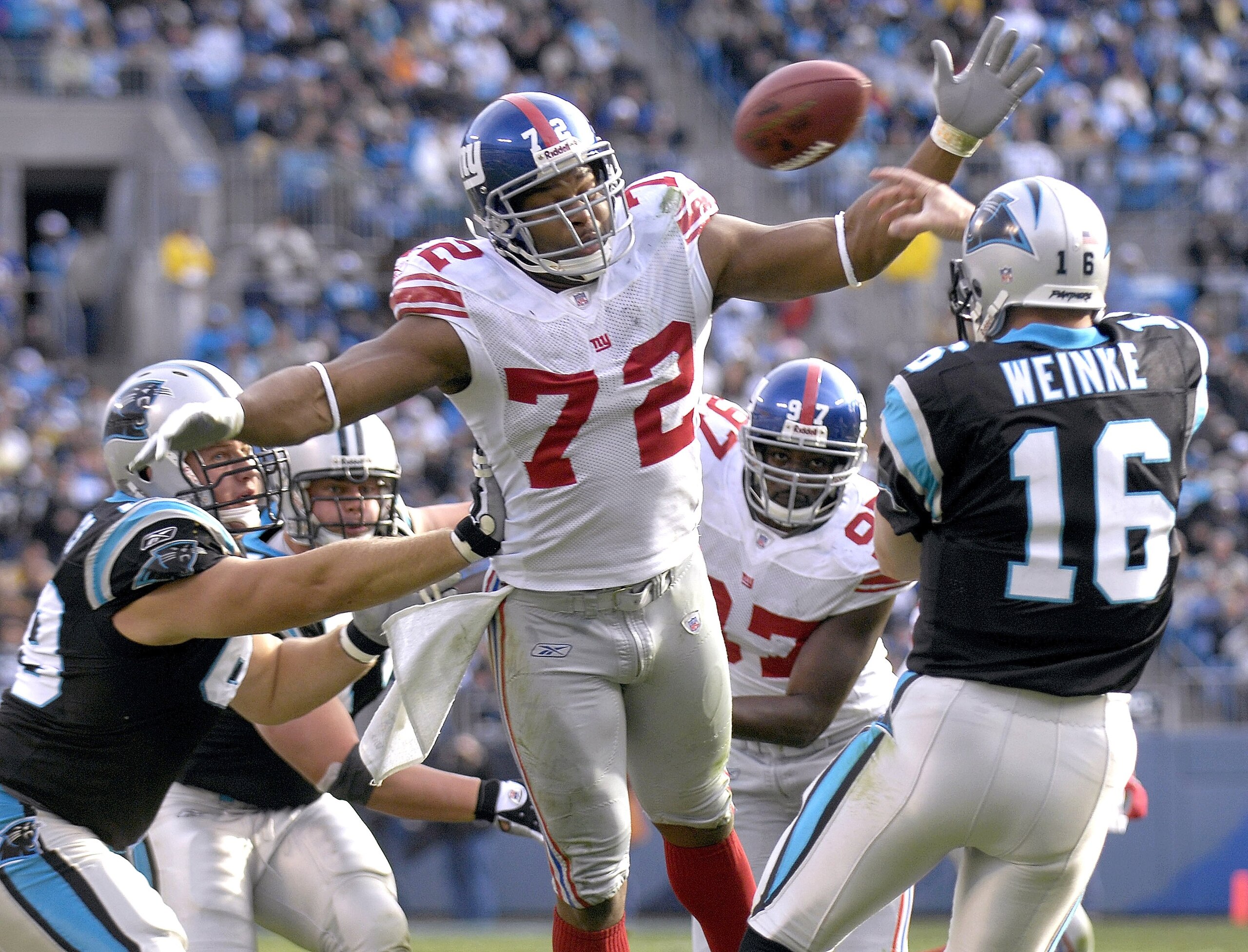 CHARLOTTE, NC - DECEMBER 10: Osi Umenyiora #72 of the New York Giants knocks down a pass by Chris Weinke #16 of the Carolina Panthers during an NFL game on December 10, 2006, at Bank of America Stadium in Charlotte, North Carolina. (Photo By Grant Halvers