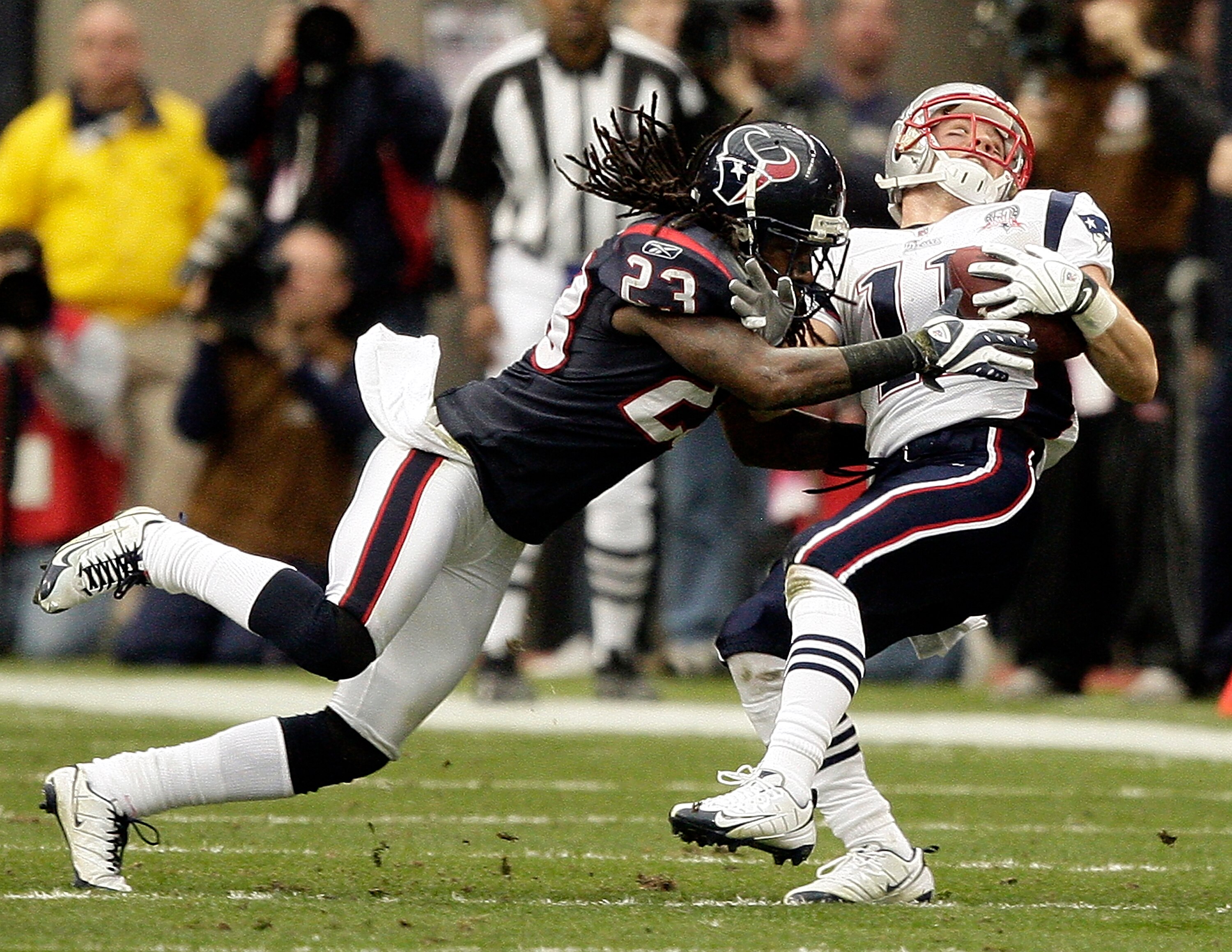 HOUSTON - JANUARY 03:  Wide receiver Julian  Edelman #11 of the New  England Patriots is tackled by cornerback Dunta Robinson #23 of the Houston Texans at Reliant Stadium on January 3, 2010 in Houston, Texas.  (Photo by Bob Levey/Getty Images)