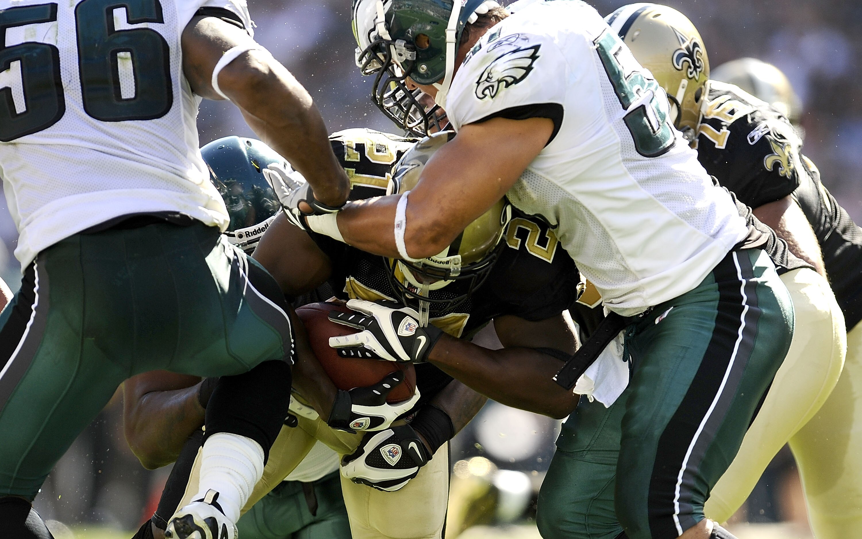 PHILADELPHIA - SEPTEMBER 20:  Mike Bell #21 of the New Orleans Saints tries to break through the defense of of Akeem Jordan #56 and Trent Cole #58 of the Philadelphia Eagles during their game at Lincoln Financial Field on September 20, 2009 in Philadelphi