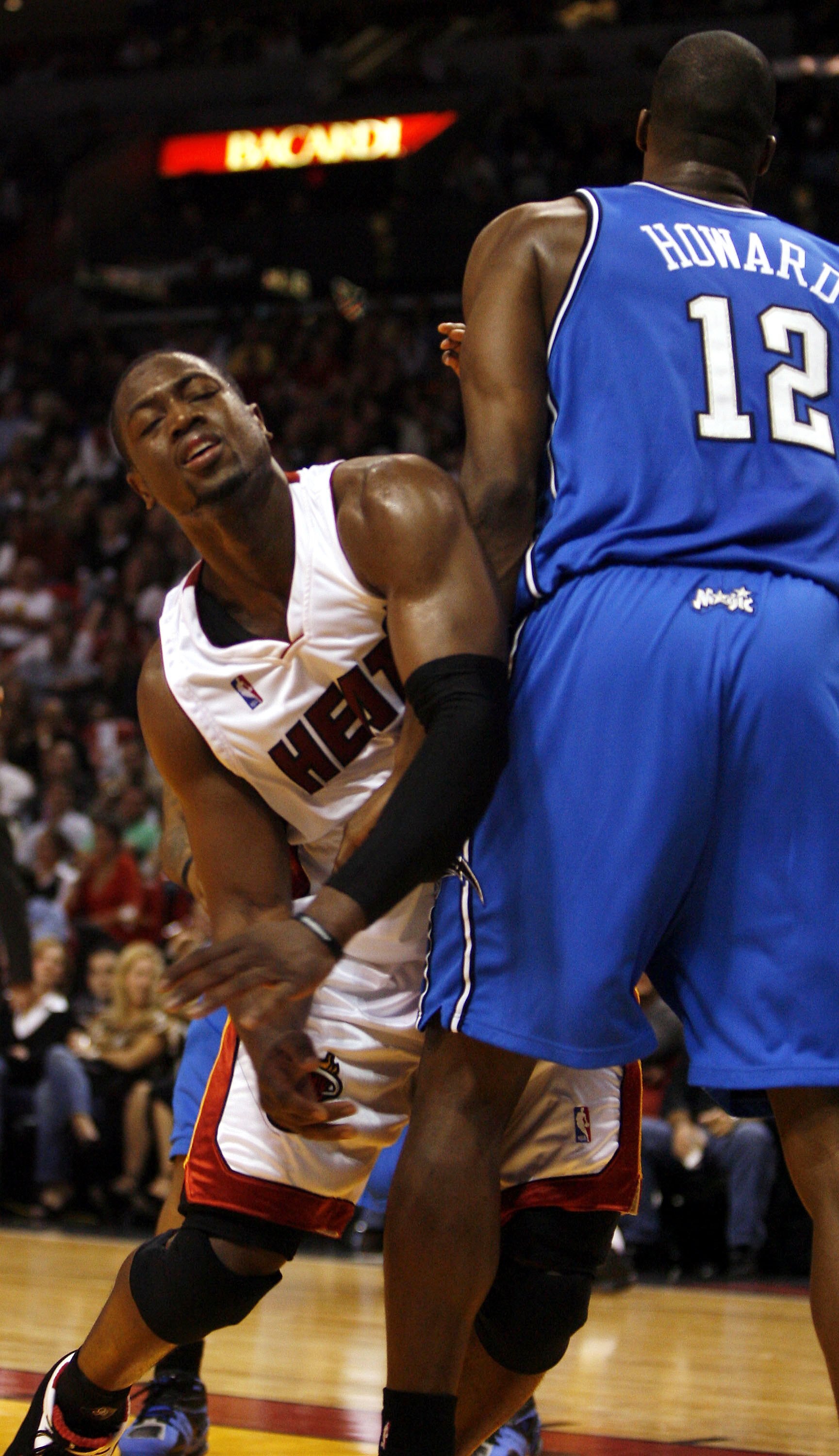 MIAMI - NOVEMBER 24:  Guard Dwyane Wade #3 of the Miami Heat bumps into forward Dwight Howard #12 of the Orlando Magic in the first half on November 24, 2006 at the American Airlines Arena in Miami, Florida. NOTE TO USER: User expressly acknowledges and a