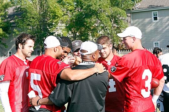Oaklandd raider quarterbacks huddle with Offensive coordinator Hue Jackson