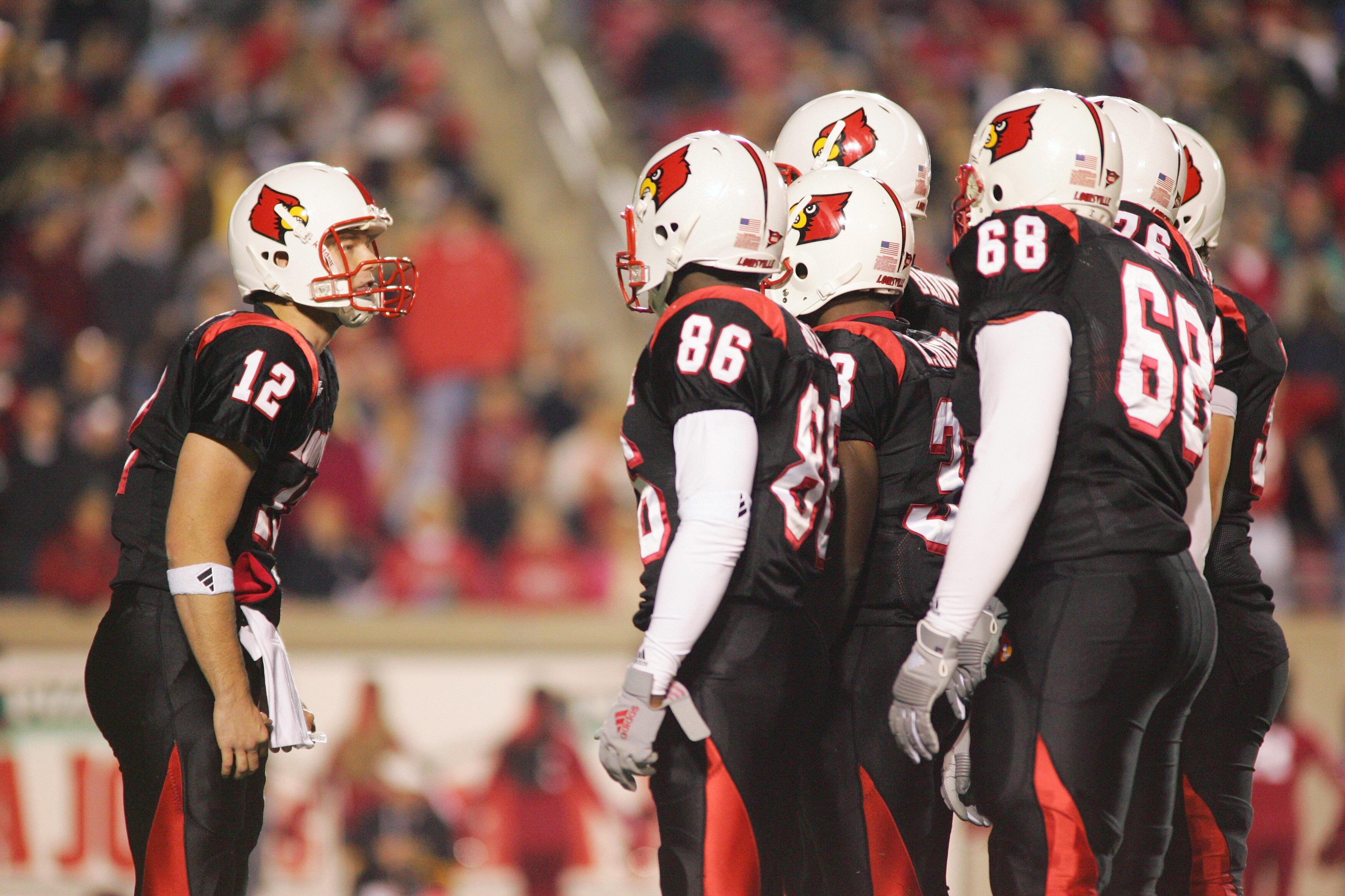 LOUISVILLE, KY - NOVEMBER 11:  Quarterback Brian Brohm #12 of the Louisville Cardinals huddles with his team against the Rutgers Scarlet Knights at Papa John's Cardinal Stadium on November 11, 2005 in Louisville, Kentucky.  Louisville defeated Rutgers 56-