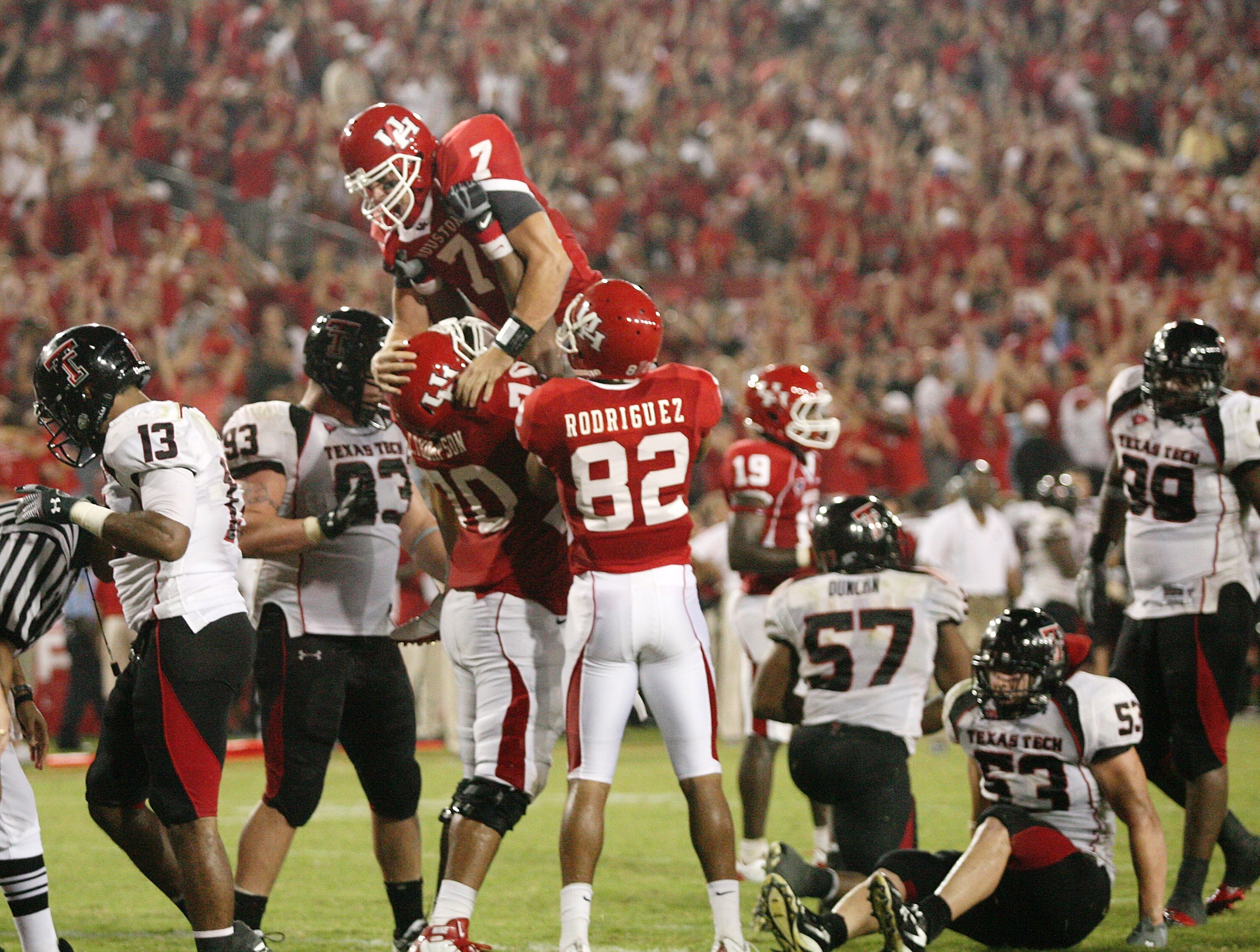 HOUSTON - SEPTEMBER 26:  Quarterback Case Keenum #7 of the Houston Cougars is lifted in the air after Kennum scored a 4 yard touchdown run to give the Cougars a 29 to 28 win over the Texas Tech Red Raiders at Robertson Stadium on September 26, 2009 in Hou