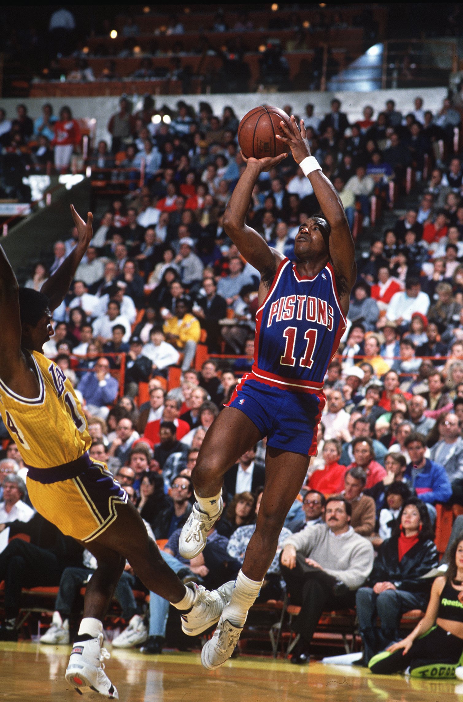 11 May 1994: DETROIT POINT GUARD ISIAH THOMAS WITH A JUMP SHOT OVER A FALLING LAKER DURING THE PISTONS GAME AT LOS ANGELES.