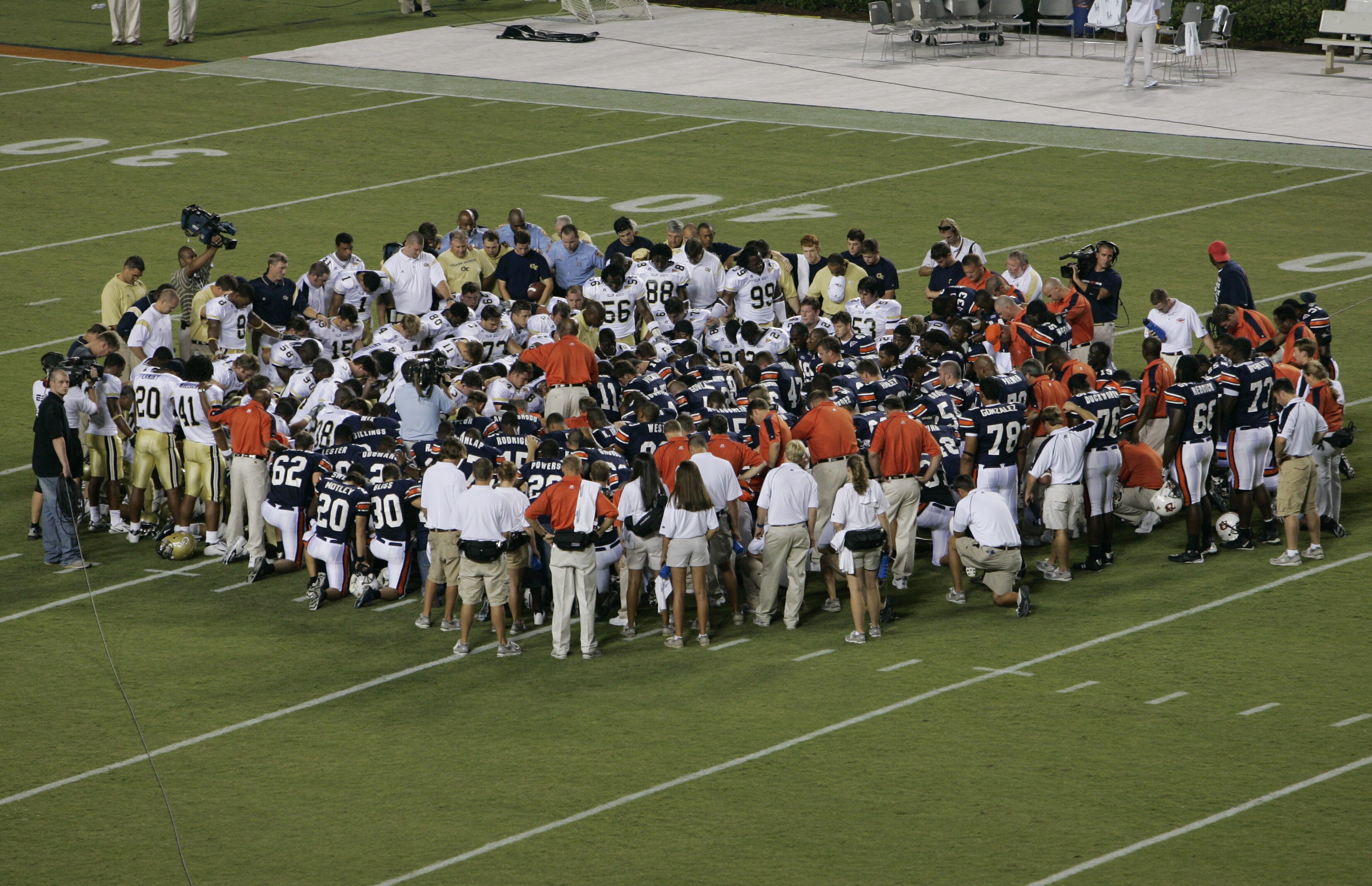 AUBURN, AL - SEPTEMBER 3:  The Auburn Tigers and the Georgia Tech Yellow Jackets players gather for a prayer for hurricane Katrina victims before the game on September 3, 2005 at Jordan-Hare Stadium in Auburn, Alabama.  (Photo by Brian Bahr/Getty Images)