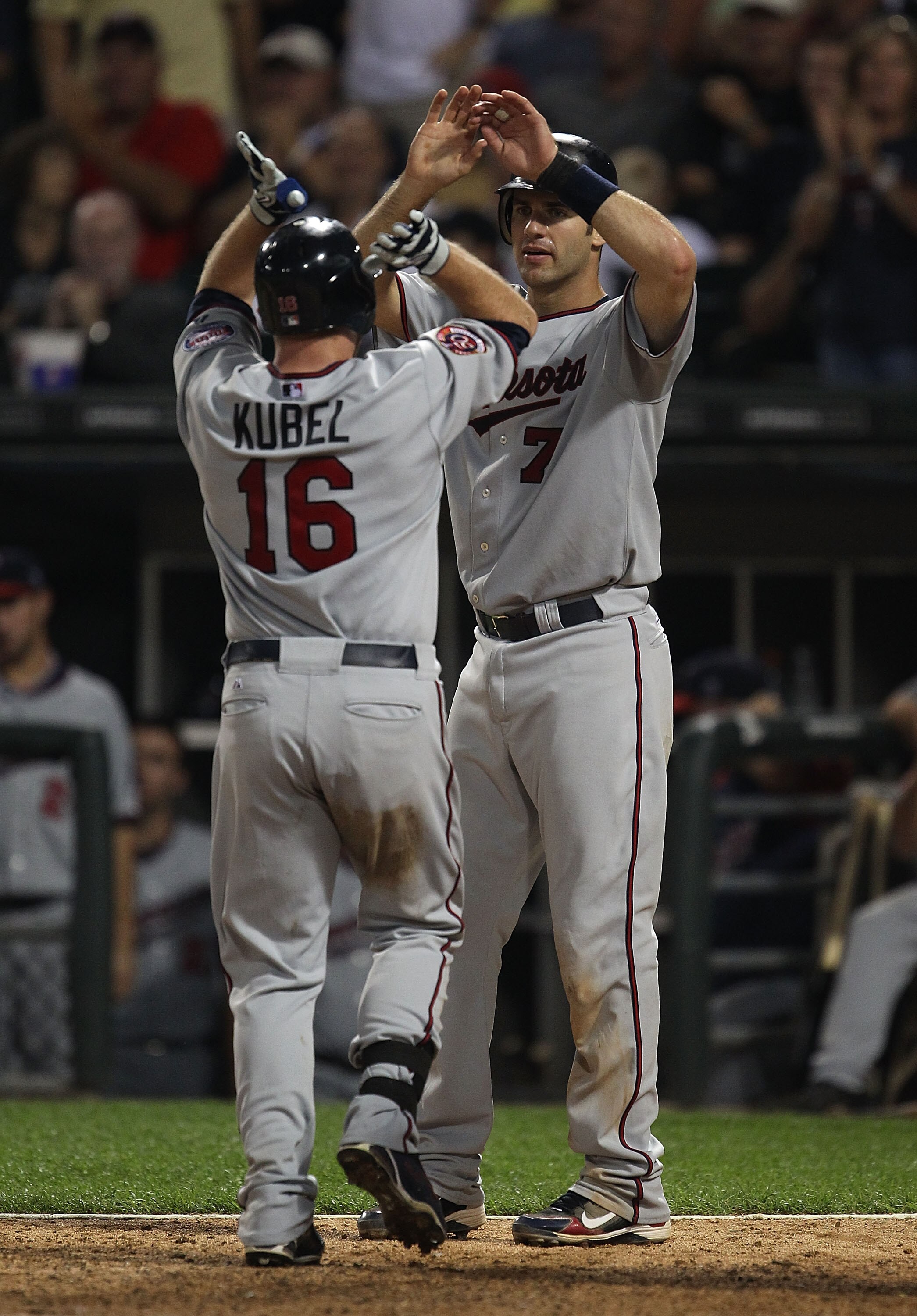 CHICAGO - AUGUST 10: Jason Kubel #16 of the Minnesota Twins is greeted at the plate by teammate Joe Mauer #7 after hitting a two-run home run in the 8th inning against the Chicago White Sox at U.S. Cellular Field on August 10, 2010 in Chicago, Illinois. T