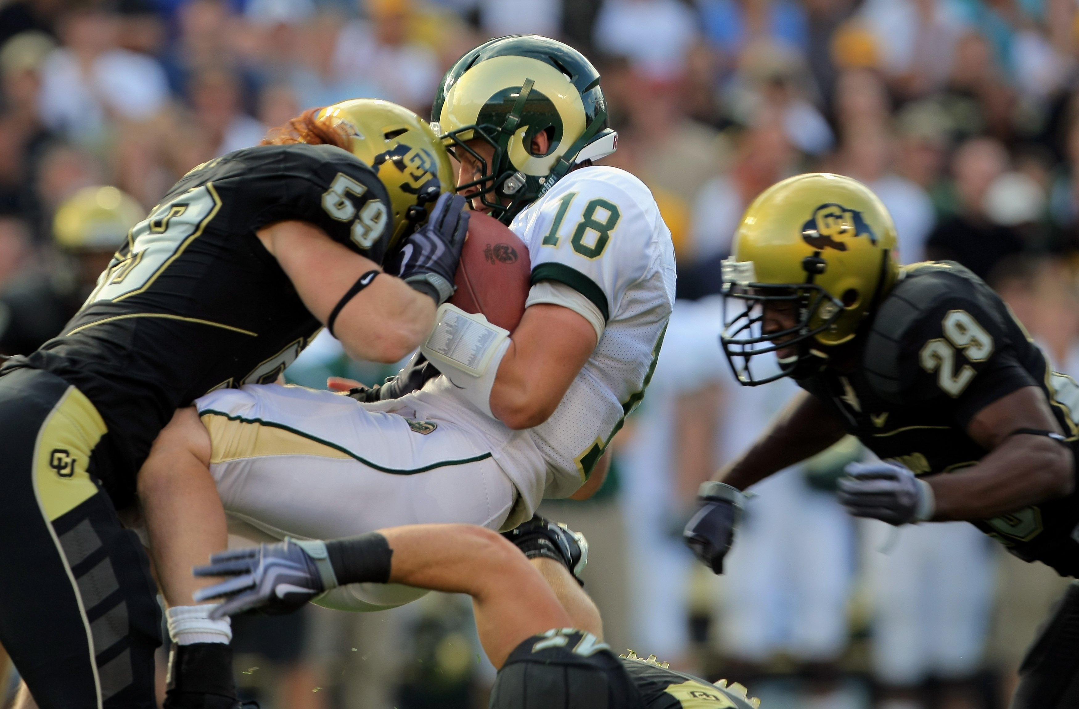 BOULDER, CO - SEPTEMBER 06:  Quarterback Grant Stucker #18 of the Colorado State Rams is tackled by linebacker B.J. Beatty #59 of the Colorado Buffaloes with help from cornerback Cha'pelle Brown #29 at Folsom Field on September 6, 2009 in Boulder, Colorad
