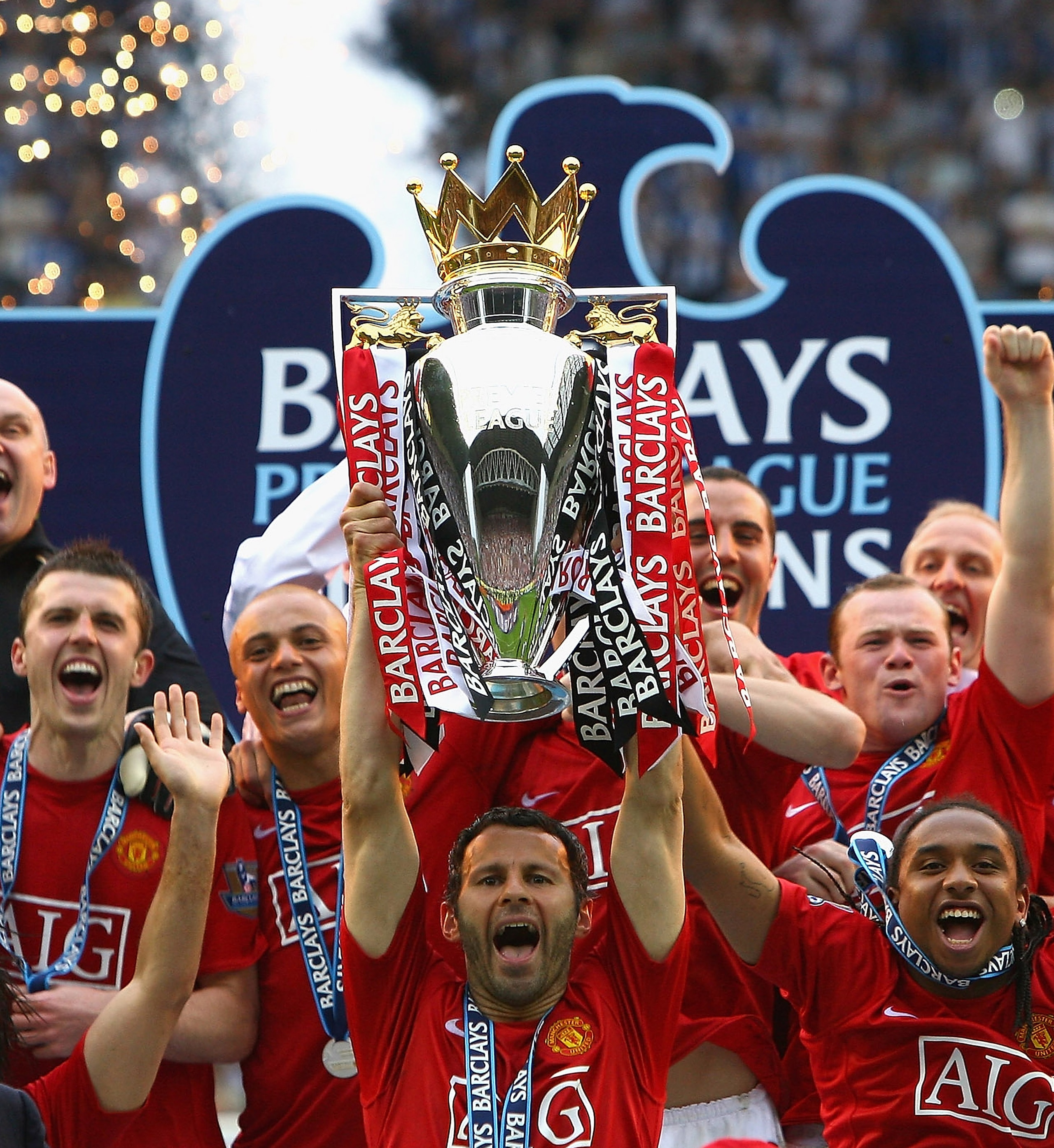 WIGAN, UNITED KINGDOM - MAY 11:  Ryan Giggs of Manchester United  lifts the Barclays Premier League trophy as his team mates celebrate following their victory at the end of the Barclays Premier League match between Wigan Athletic and Manchester United at