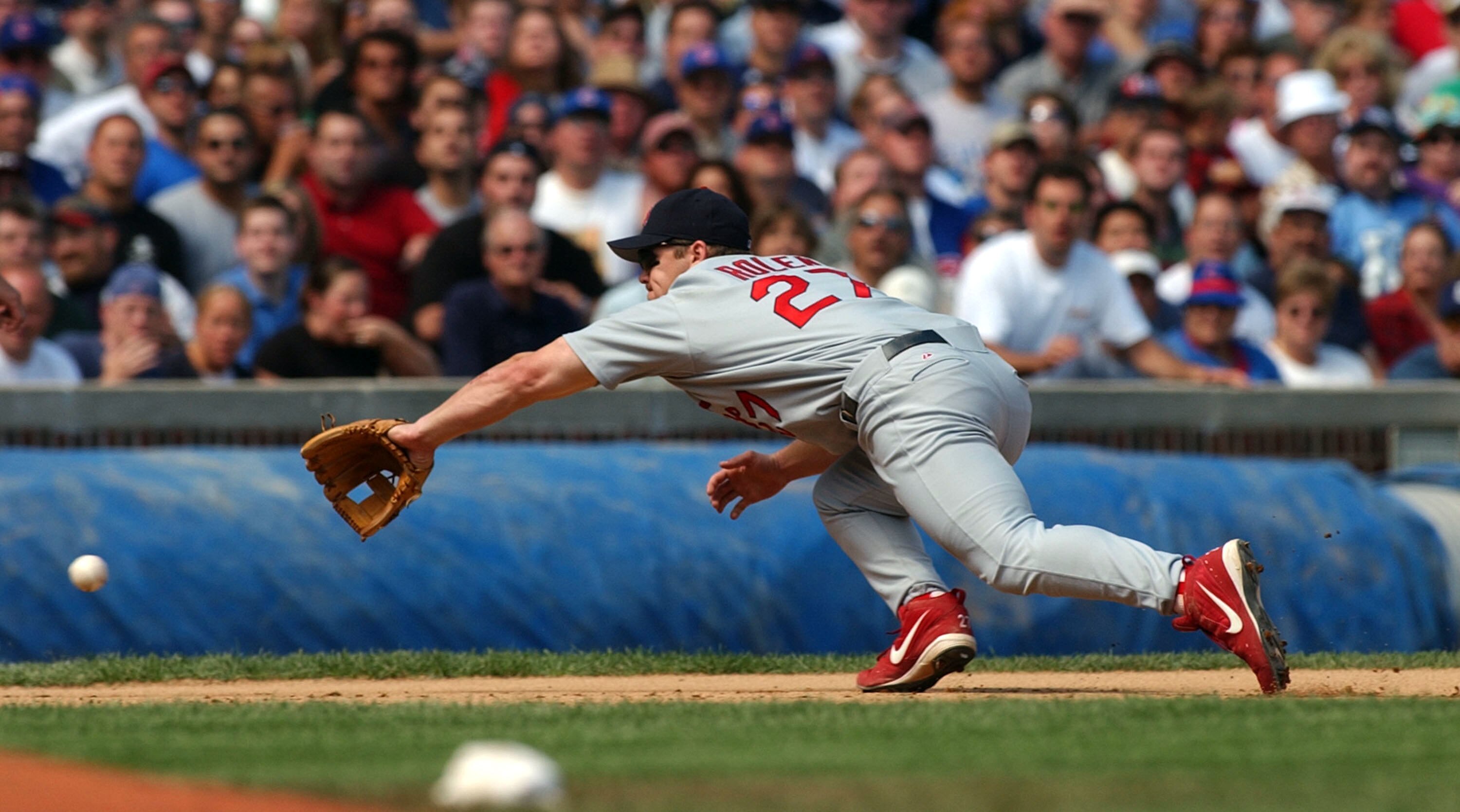 CHICAGO - SEPTEMBER 2:  Third baseman Scott Rolen #27 of the St. Louis Cardinals dives in an unsuccessful attempt to snag a grounder hit by catcher Damian Miller of the Chicago Cubs during a game September 2, 2003 at Wrigley Field in Chicago, Illinois. Th