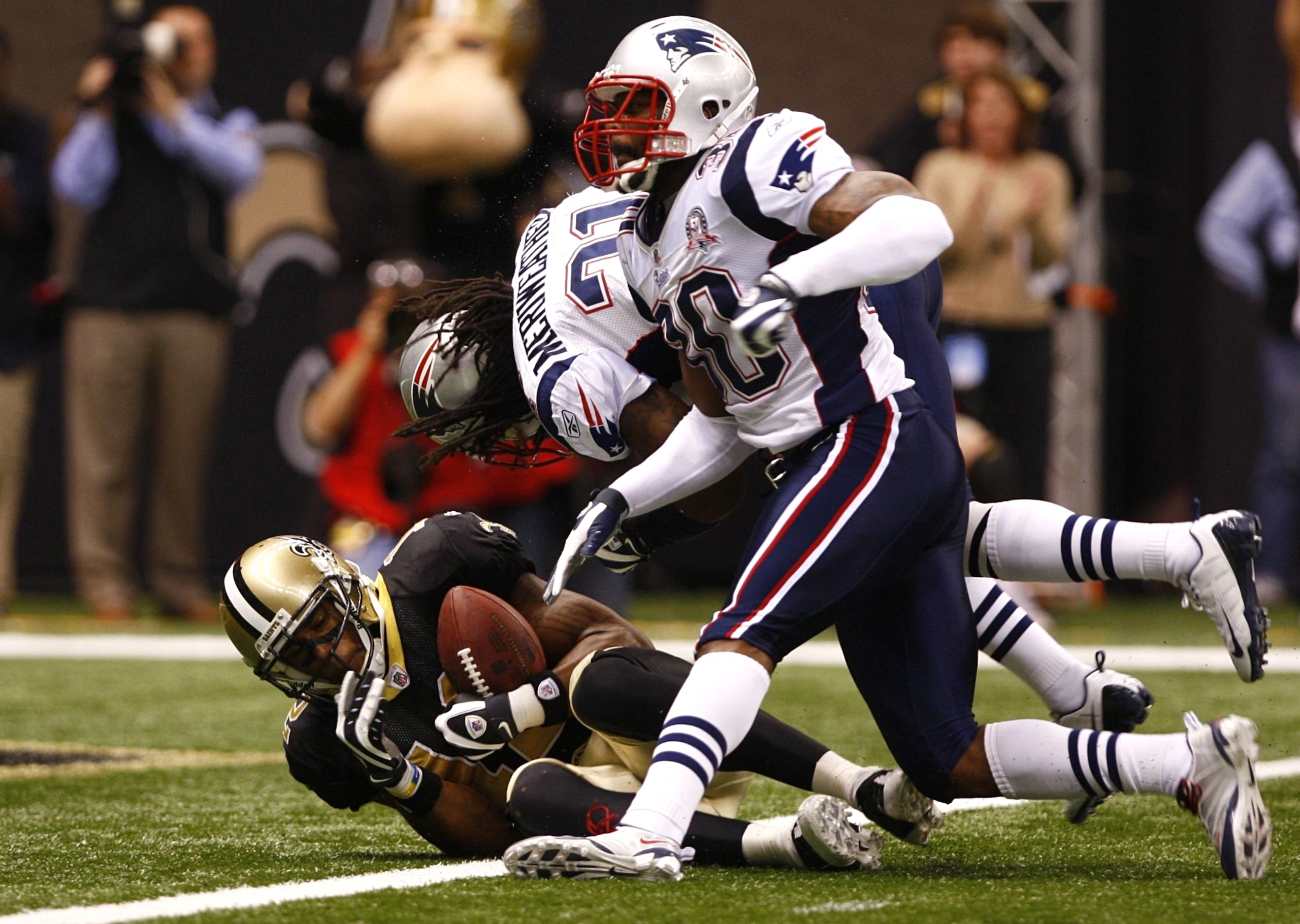 NEW ORLEANS - NOVEMBER 30: Marques Colston #12 of the New Orleans Saints catches a 20-yard touchdown reception in the fourth quarter against Brandon McGowan #30 and Brandon Meriweather #31 of the New England Patriots at Louisana Superdome on November 30,