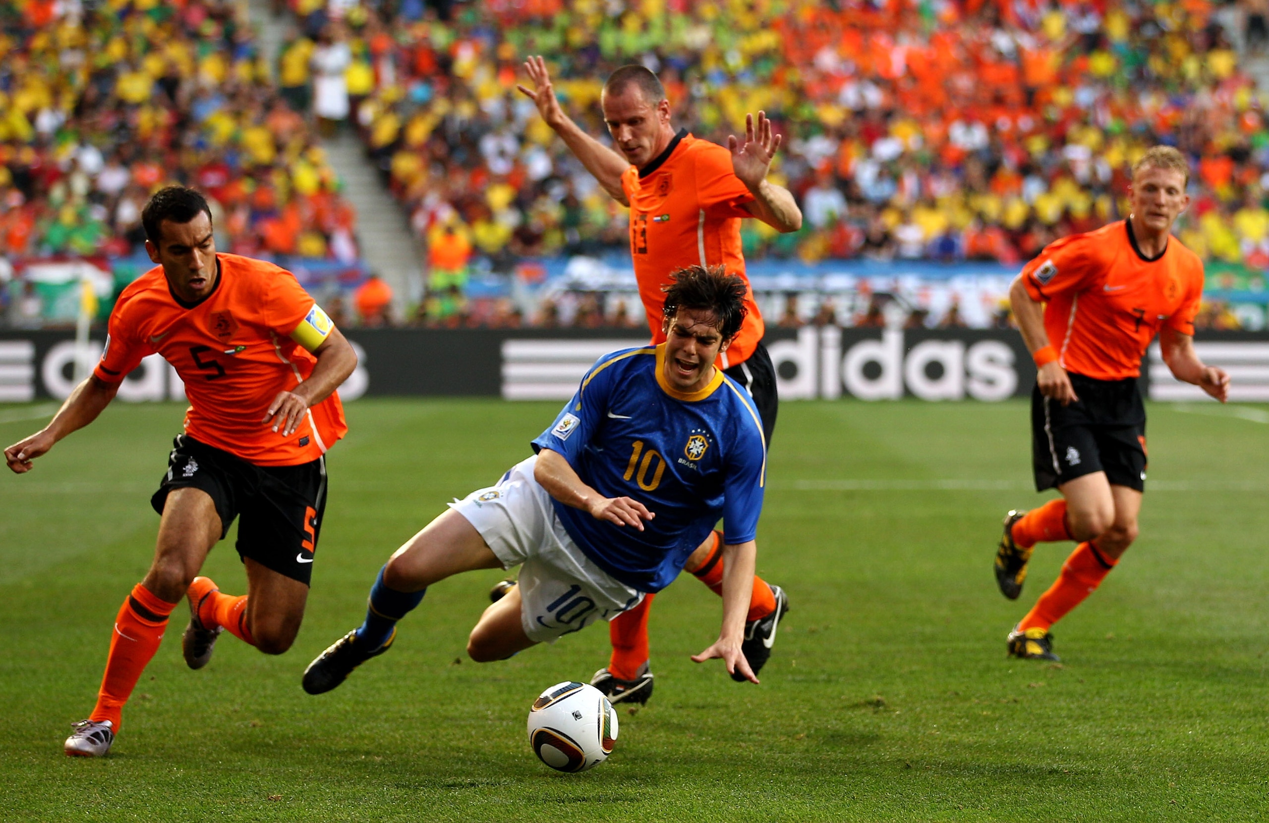 PORT ELIZABETH, SOUTH AFRICA - JULY 02:  Kaka of Brazil is brought down by Giovanni Van Bronckhorst and Andre Ooijer of The Netherlands during the 2010 FIFA World Cup South Africa Quarter Final match between Netherlands and Brazil at Nelson Mandela Bay St