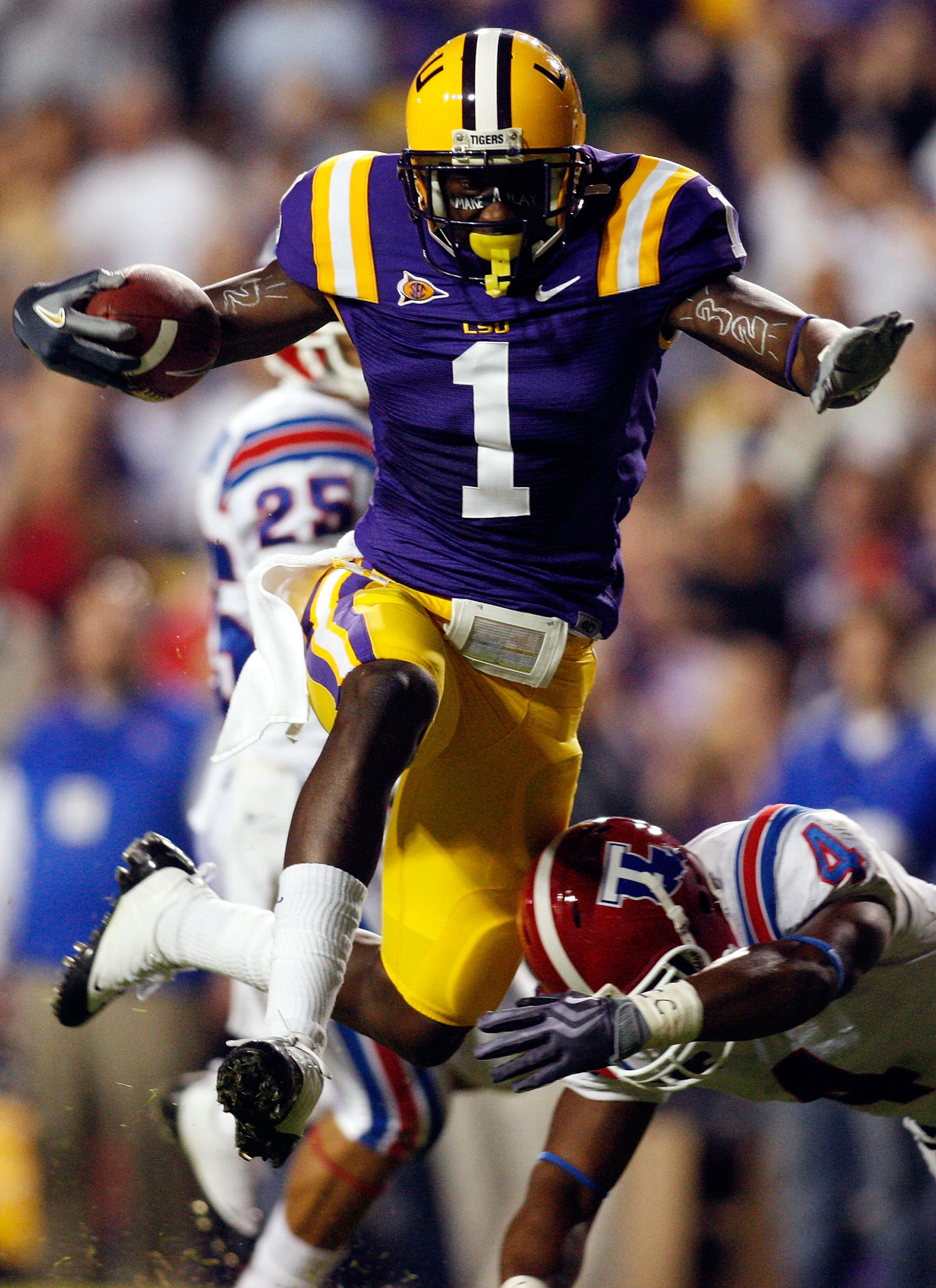 BATON ROUGE, LA - NOVEMBER 14:  Brandon LaFell #1 of the LSU Tigers jumps over Jai Eugene #4 of the Louisiana Tech Bulldogs on his way to scoring a touchdown at Tiger Stadium on November 14, 2009 in Baton Rouge, Louisiana.  (Photo by Chris Graythen/Getty