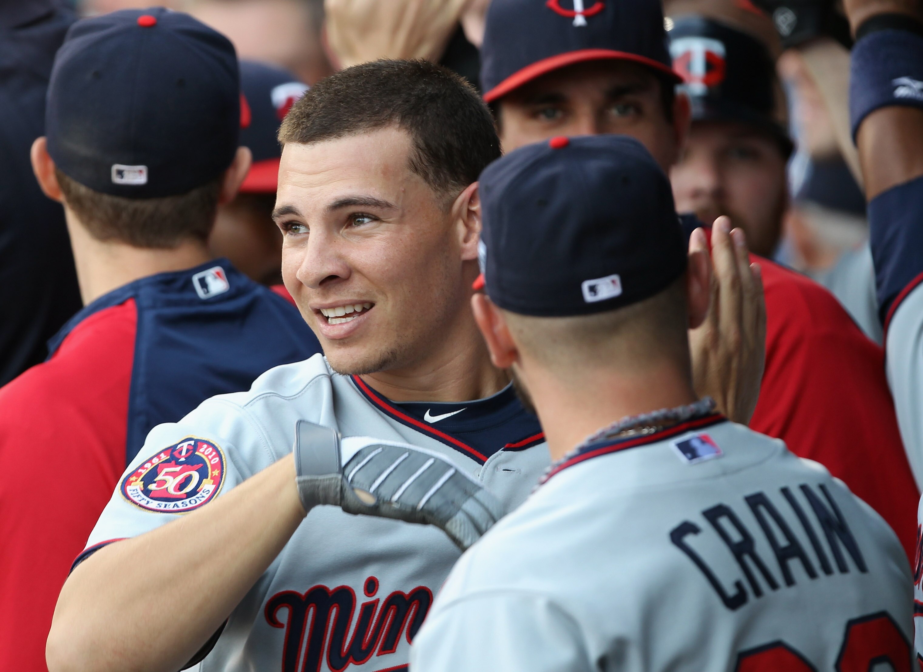 KANSAS CITY, MO - JULY 26:  Danny Valencia #19 of the Minnesota Twins is congratulated by teammates in the dugout after hitting a grand slam home run during the 1st inning of the game against the Kansas City Royals on July 26, 2010 at Kauffman Stadium in