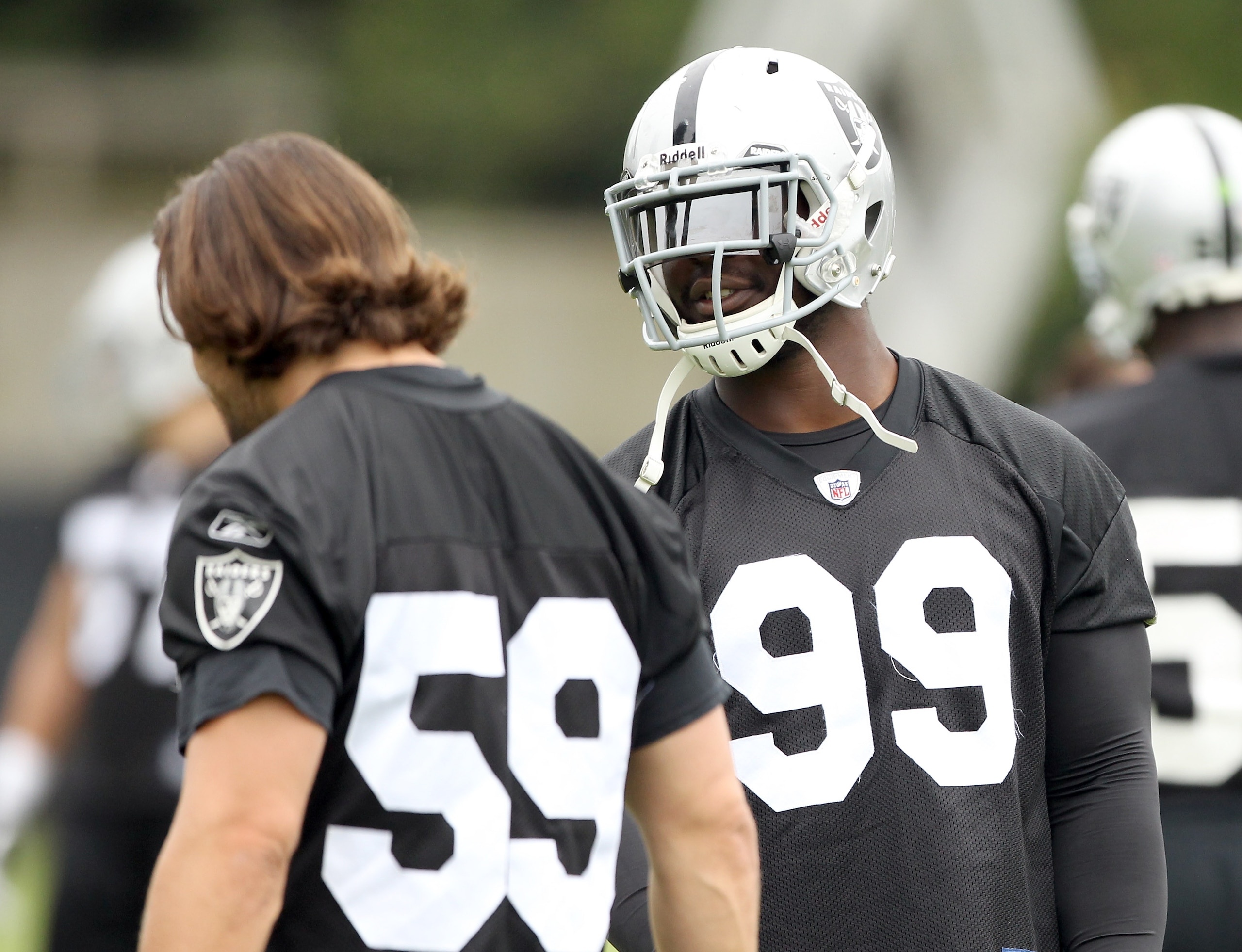 NAPA, CA - AUGUST 01:  Lamarr Houston #99 of the Oakland Raiders talks to Jon Condo #59 during the Raiders training camp at their Napa Valley Training Complex on August 1, 2010 in Napa, California.  (Photo by Ezra Shaw/Getty Images)