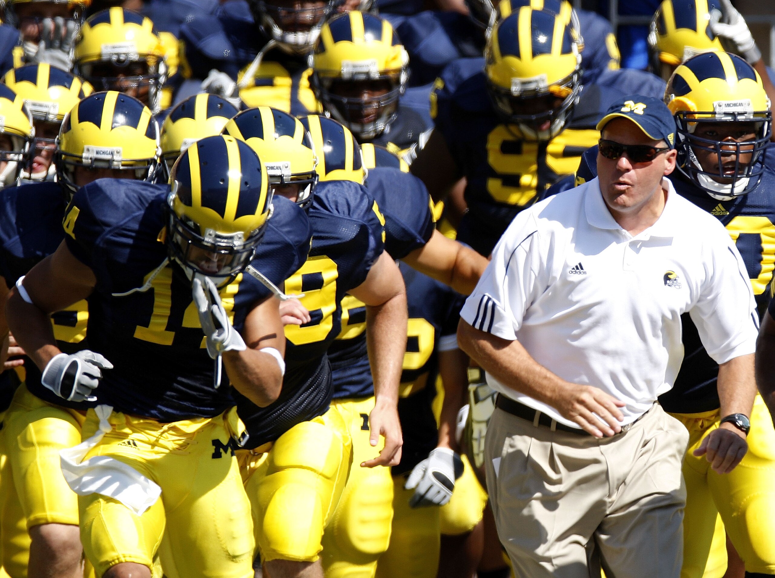 ANN ARBOR, MI - AUGUST 30: Head coach Rich Rodriguez of the Michigan Wolverines leads his team onto the field next to Morgan Trent #14 prior to playing the Utah Utes on August 30, 2008 at Michigan Stadium in Ann Arbor, Michigan. (Photo by Gregory Shamus ANN ARBOR, MI - AUGUST 30: Head coach Rich Rodriguez of the Michigan Wolverines leads his team onto the field next to Morgan Trent #14 prior to playing the Utah Utes on August 30, 2008 at Michigan Stadium in Ann Arbor, Michigan. (Photo by Gregory Shamus