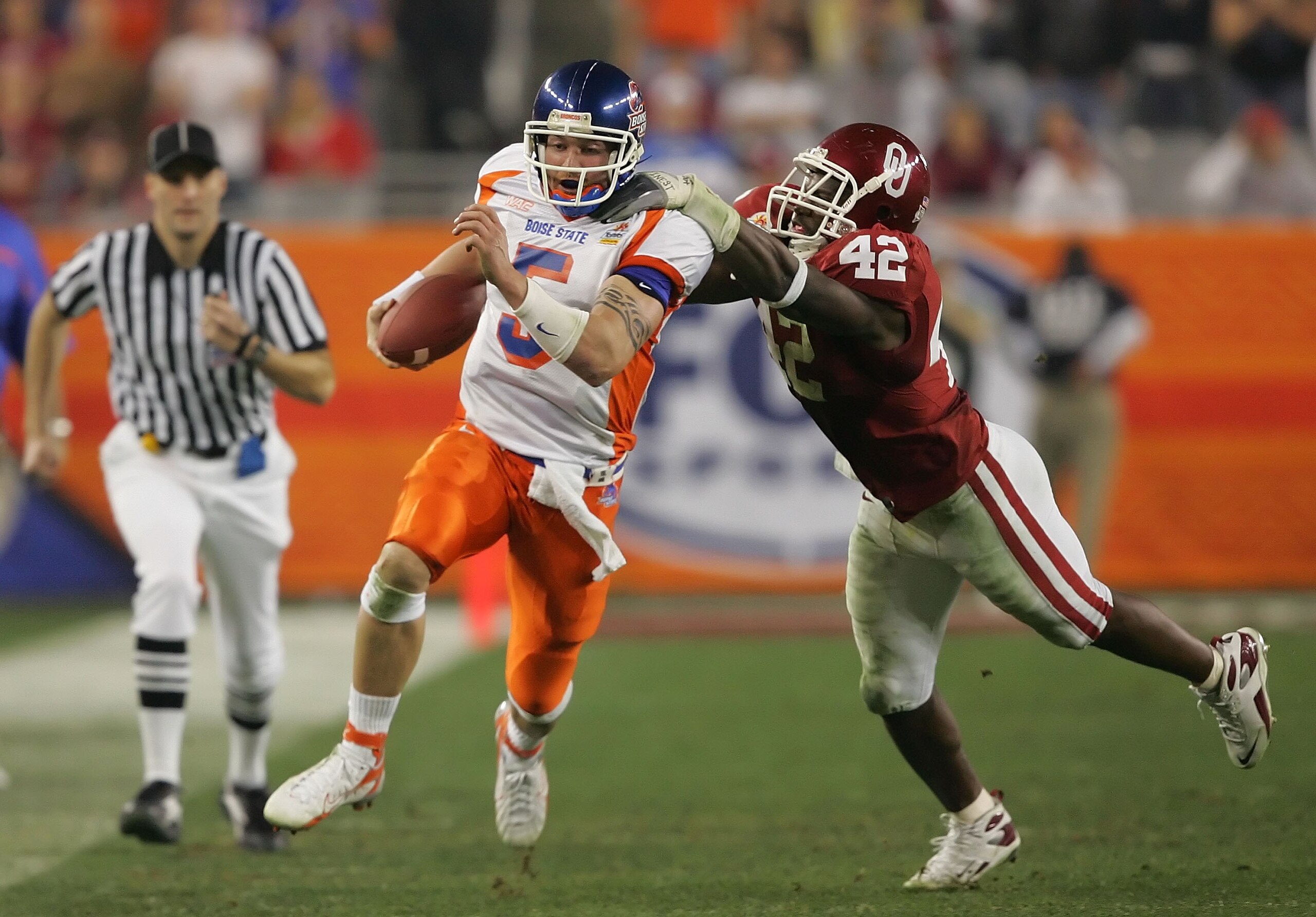 GLENDALE, AZ - JANUARY 01:  Quarterback Jared Zabransky #5 of the Boise State Broncos is grabbed by the back of the jersey by linebacker Rufus Alexander #42 of the Oklahoma Sooners in the second quarter at the Tostito's Fiesta Bowl at University of Phoeni