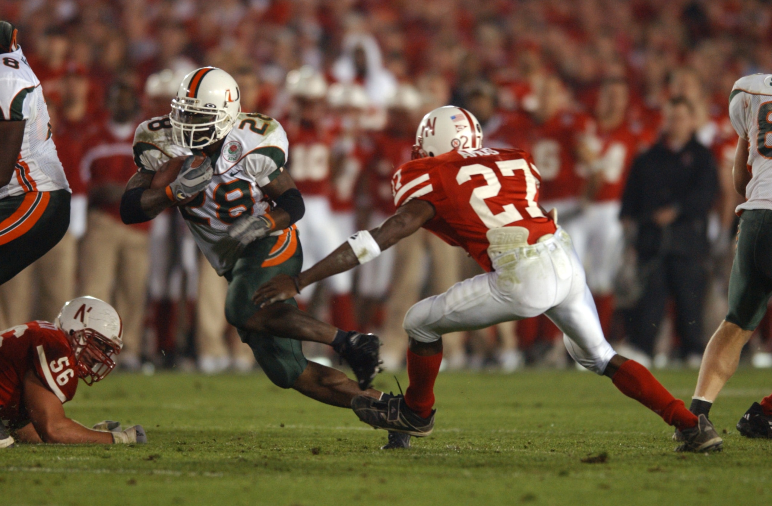 3 Jan 2002:  Clinton Portis #28 of Miami carries the football against the defense of Willie Amos #27 of Nebraska during the Rose Bowl National Championship game at the Rose Bowl in Pasadena, California.  Miami won the game 37-14, winning the BCS and the N