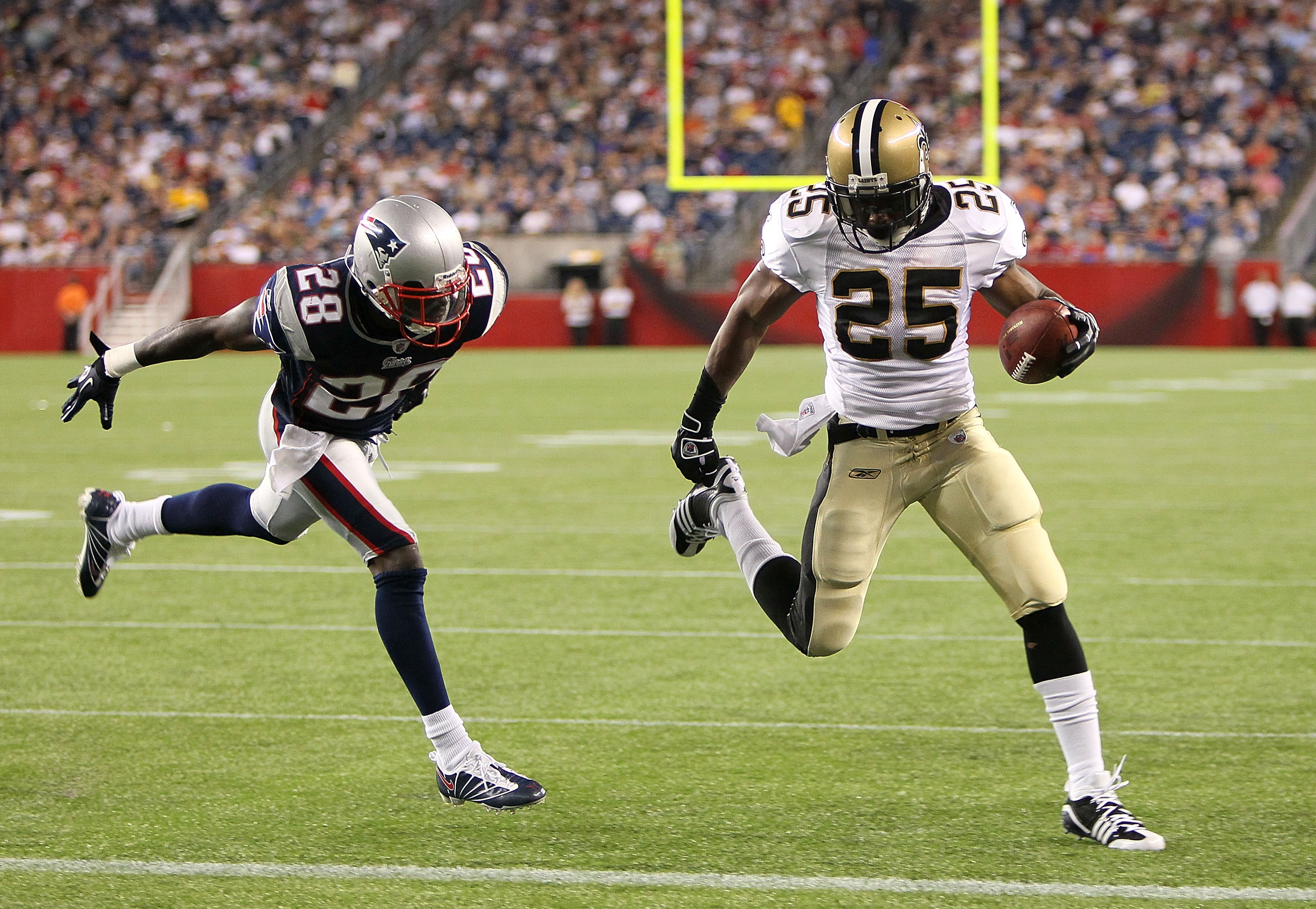 FOXBORO, MA - AUGUST 12: Reggie Bush # 25 of the New Orleans Saints scores a touchdown against the defense of Darius Butler # 28 of the New England Patriots during the preseason game against the New England Patriots at Gillette Stadium on August 12, 2010